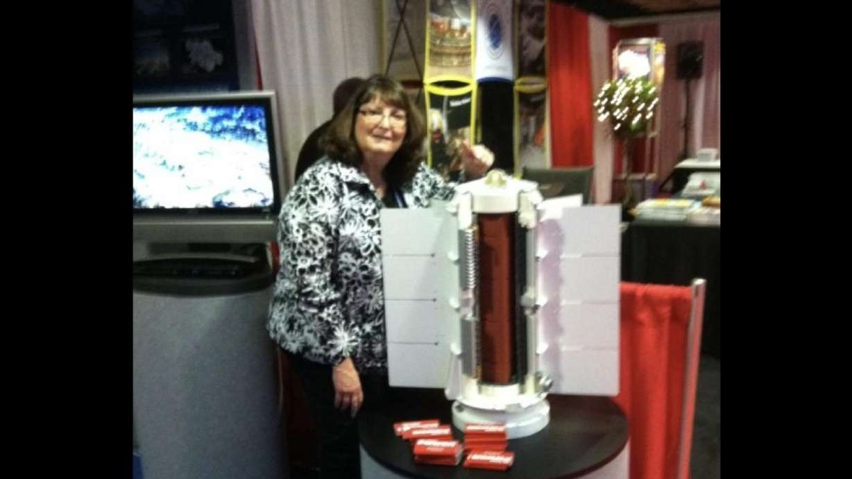 Teri Hillyard Ehresman poses with a mockup of the space battery used for NASA’s Curiosity rover. Ehresman used the display at conferences leading up to the rover’s launch as part of her communications work.