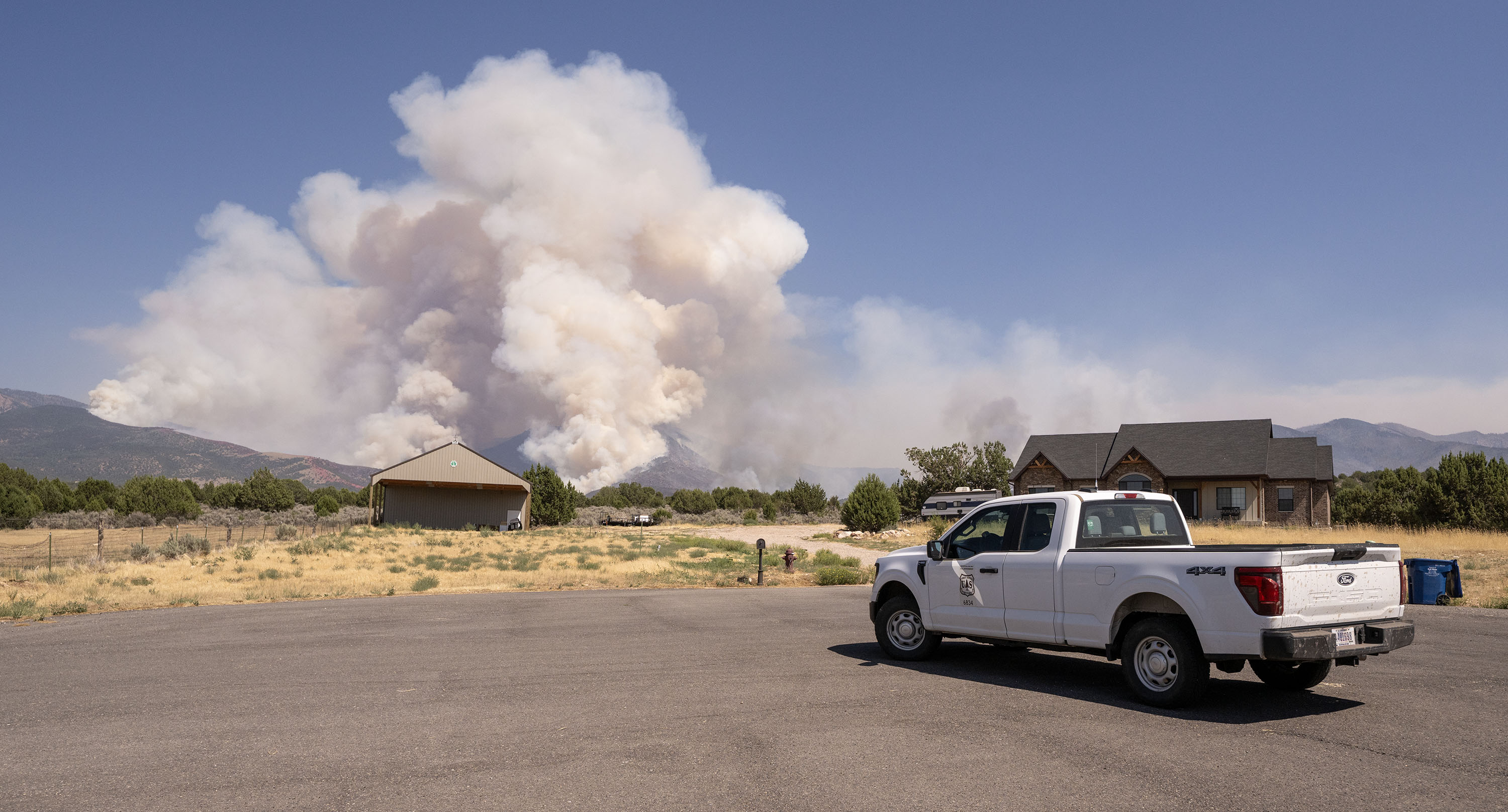 A Forest Service employee watches the Widemouth 2 Fire as it burned in the mountains east of Fillmore on Aug. 4, 2026.