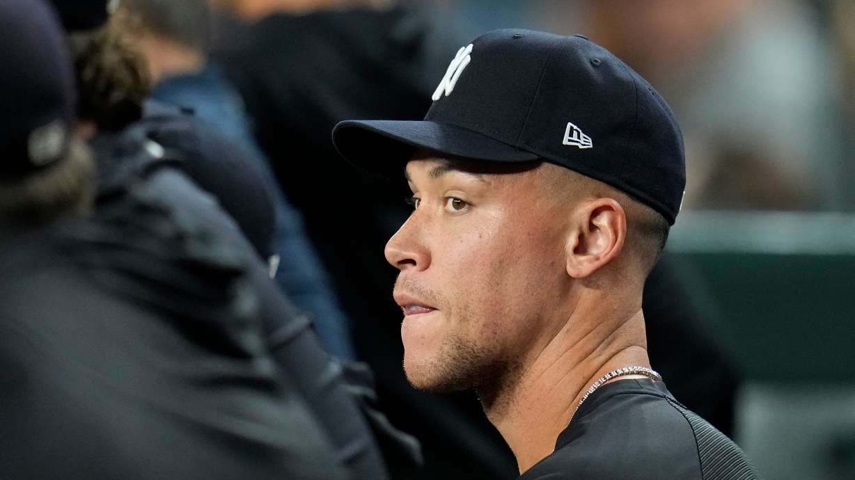 Injured New York Yankees' Aaron Judge sits with teammates in the dugout during the sixth inning of a baseball game against the Arizona Diamondbacks, Friday, Sept. 18, 2026, in Phoenix.
