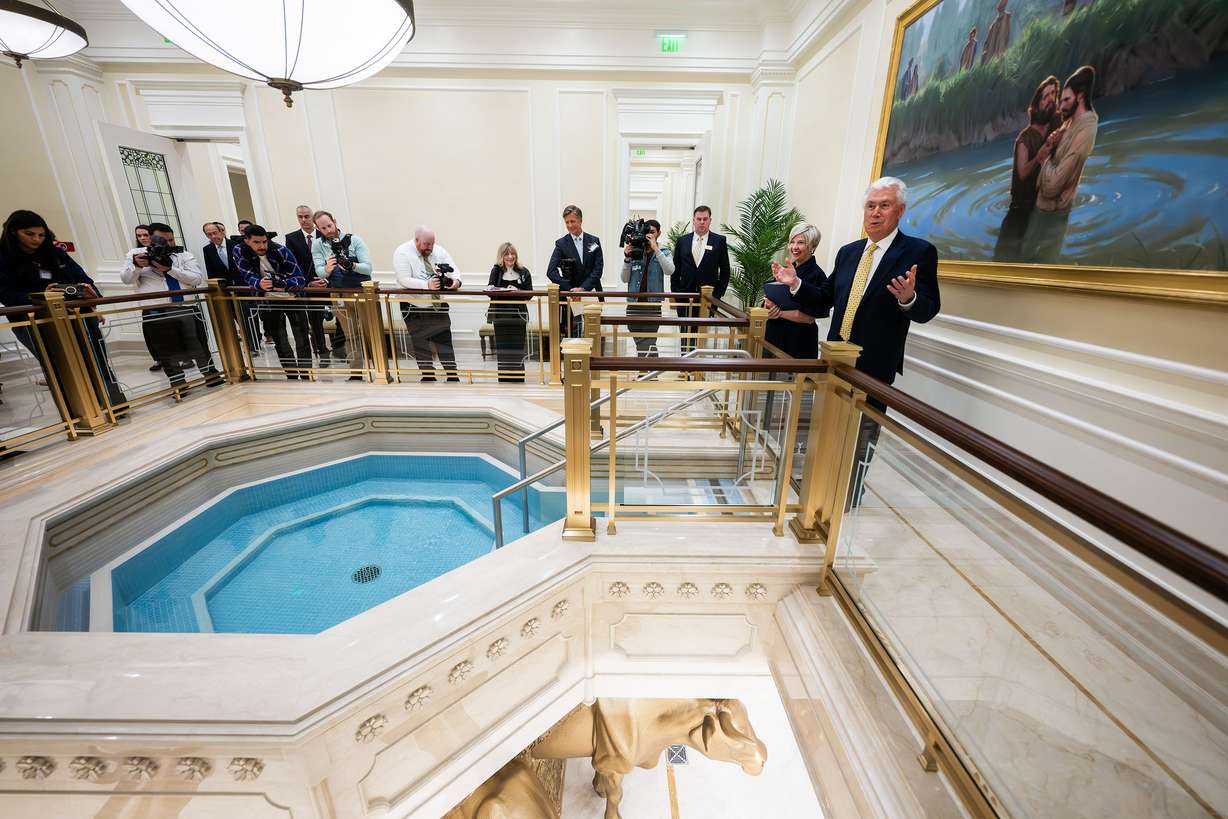 President Dieter F. Uchtdorf and President Emily Belle Freeman lead members of the media on a tour showing a full-scale replica of a temple baptistry room in the Temple Square Visitors' Center in Salt Lake City on April 13.