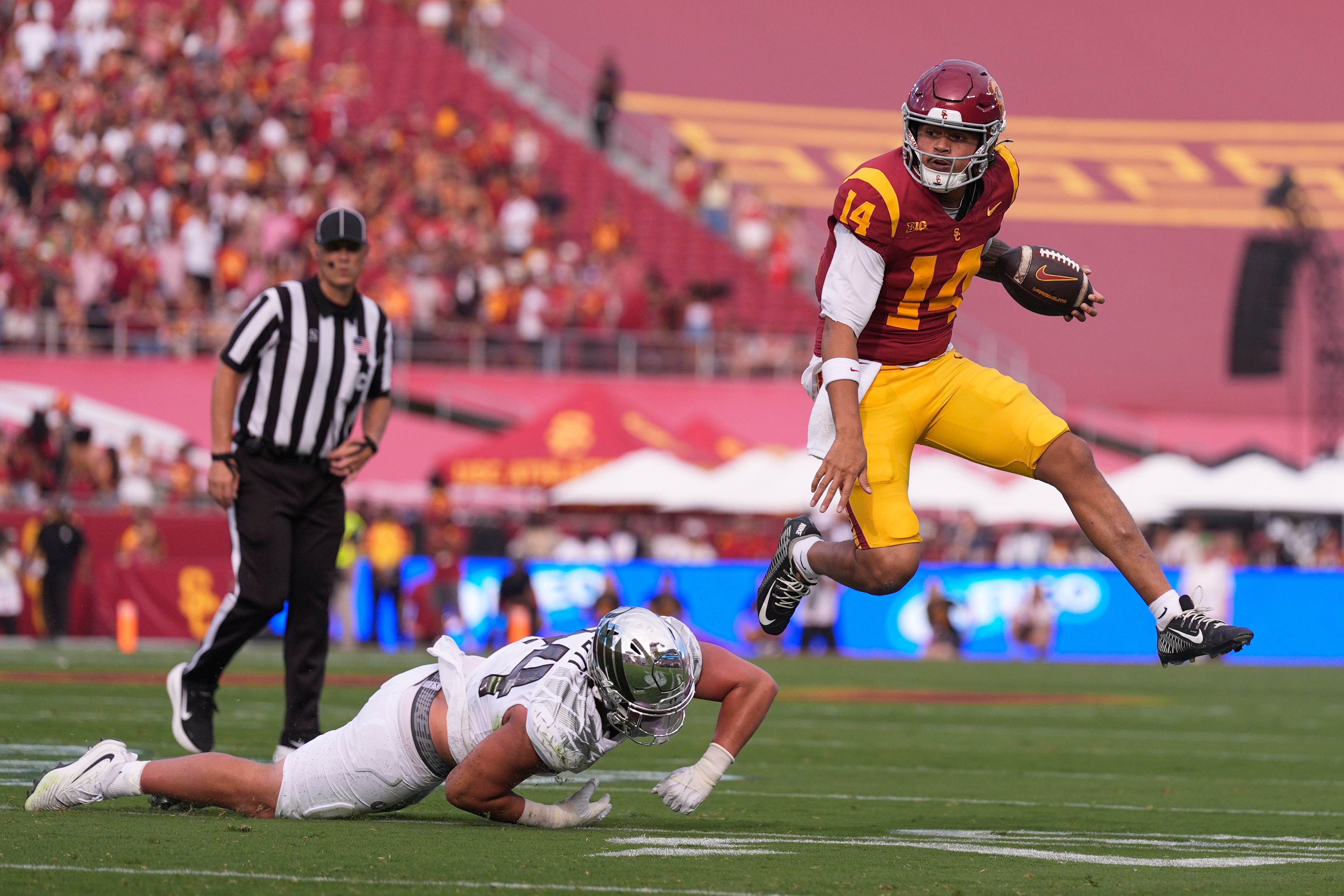 Southern California quarterback Jayden Maiava, right, jumps away from Oregon linebacker Teitum Tuioti during the first half of an NCAA college football game, Saturday, Sept. 26, 2026, in Los Angeles. 