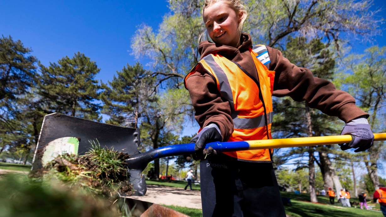 Sara Jane Giles, a senior at Farmington High School, puts grass into a wheelbarrow while volunteering at a Salt Lake City Department of Public Lands Earth Day event at Jordan Park in Salt Lake City on April 19, 2025.