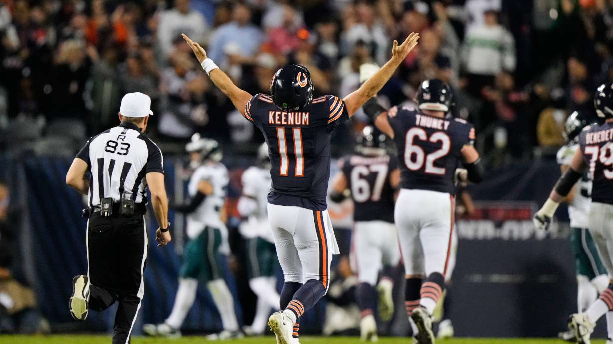 Chicago Bears quarterback Case Keenum (11) celebrates after throwing a touchdown pass to wide receiver Kalif Raymond as referee Shawn Hochuli (83) runs past during the second half of an NFL football game against the Philadelphia Eagles in Chicago, Monday, Sept. 28, 2026.