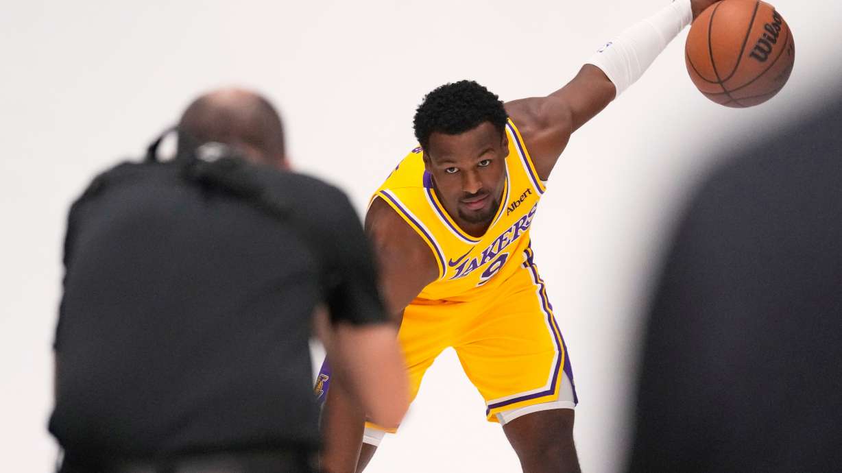 Los Angeles Lakers guard Bronny James poses for pictures with NBA photographer Adam Pantozzi during media day Monday, Sept. 28, 2026, in El Segundo, Calif.