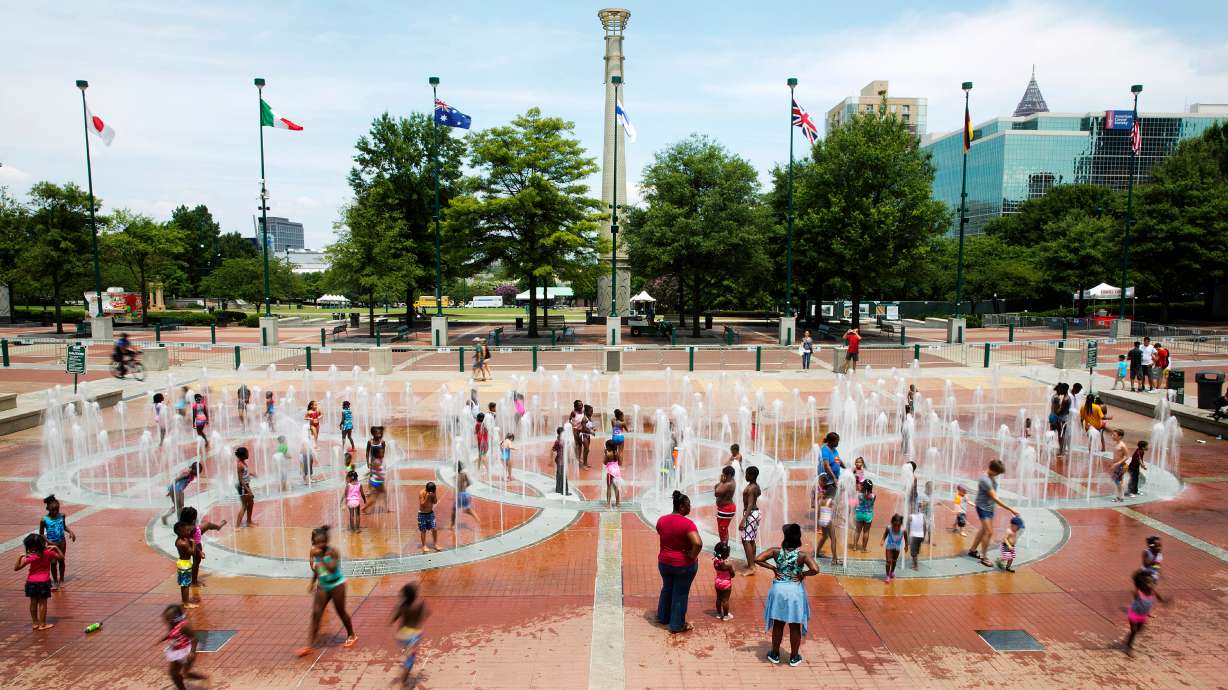 FILE - In this Friday, July 22, 2016 photo, people play in the fountains shaped by the Olympic rings at Centennial Olympic Park in Atlanta.