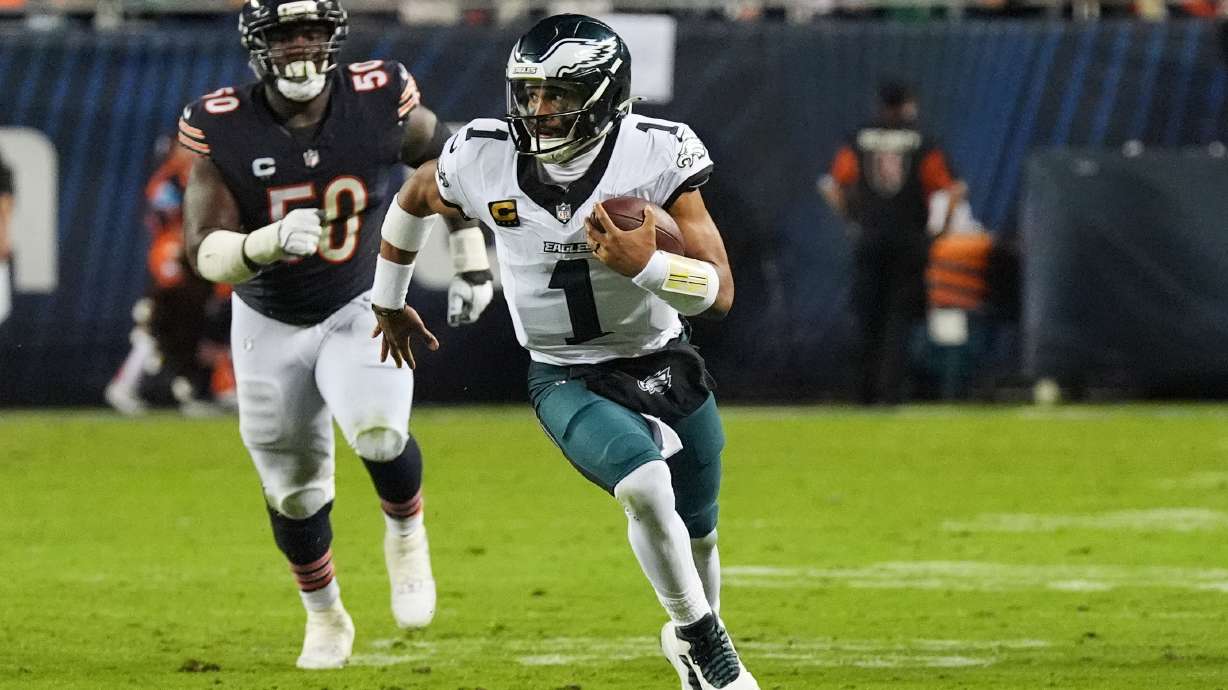 Philadelphia Eagles quarterback Jalen Hurts (1) runs the ball as Chicago Bears defensive end Grady Jarrett (50) gives chase during the second half of an NFL football game in Chicago, Monday, Sept. 28, 2026.