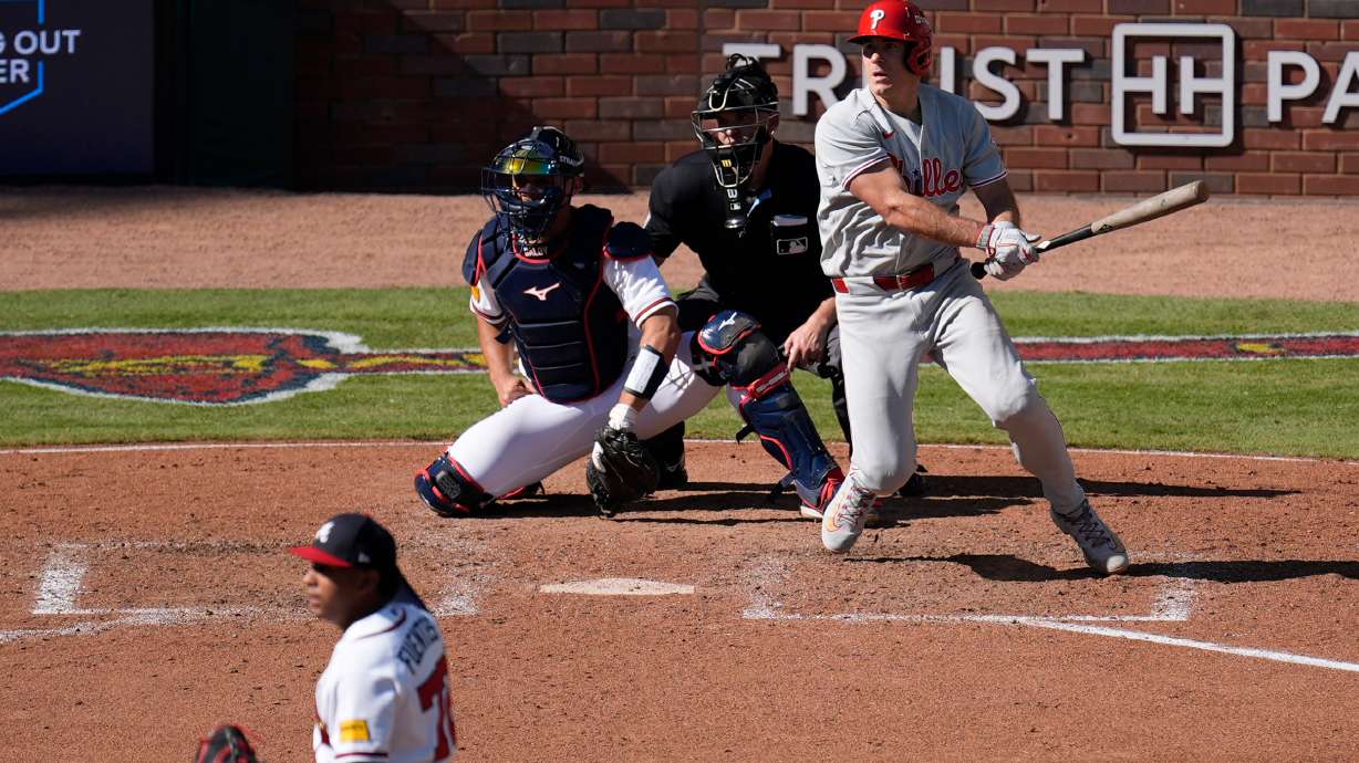 Philadelphia Phillies' J.T. Realmuto hits a two-run triple off Atlanta Braves pitcher Didier Fuentes (72) in the seventh inning during Game 1 of baseball's National League Wild Card Series Tuesday, Sept. 29, 2026, in Atlanta.