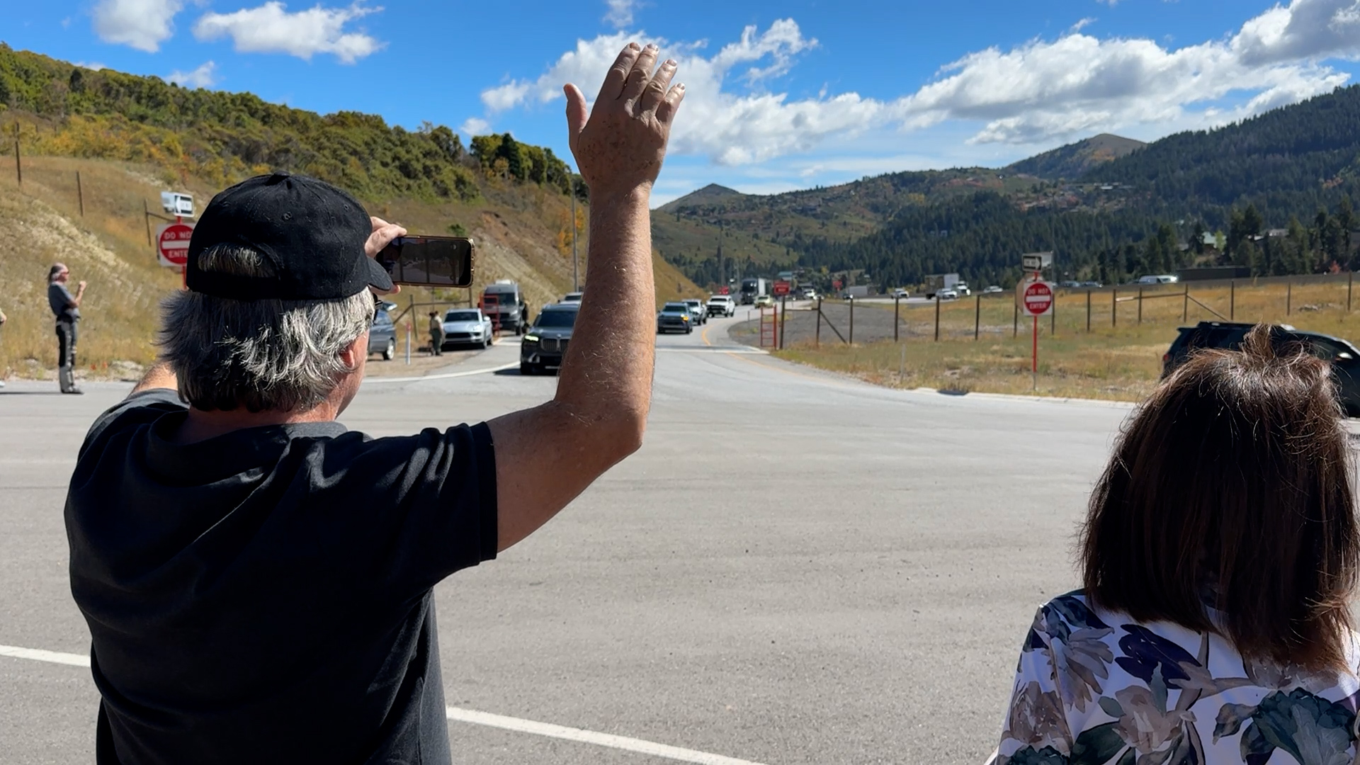 Tom Riley, who lives in Jeremy Ranch, waving to the procession as it goes by on Tuesday.