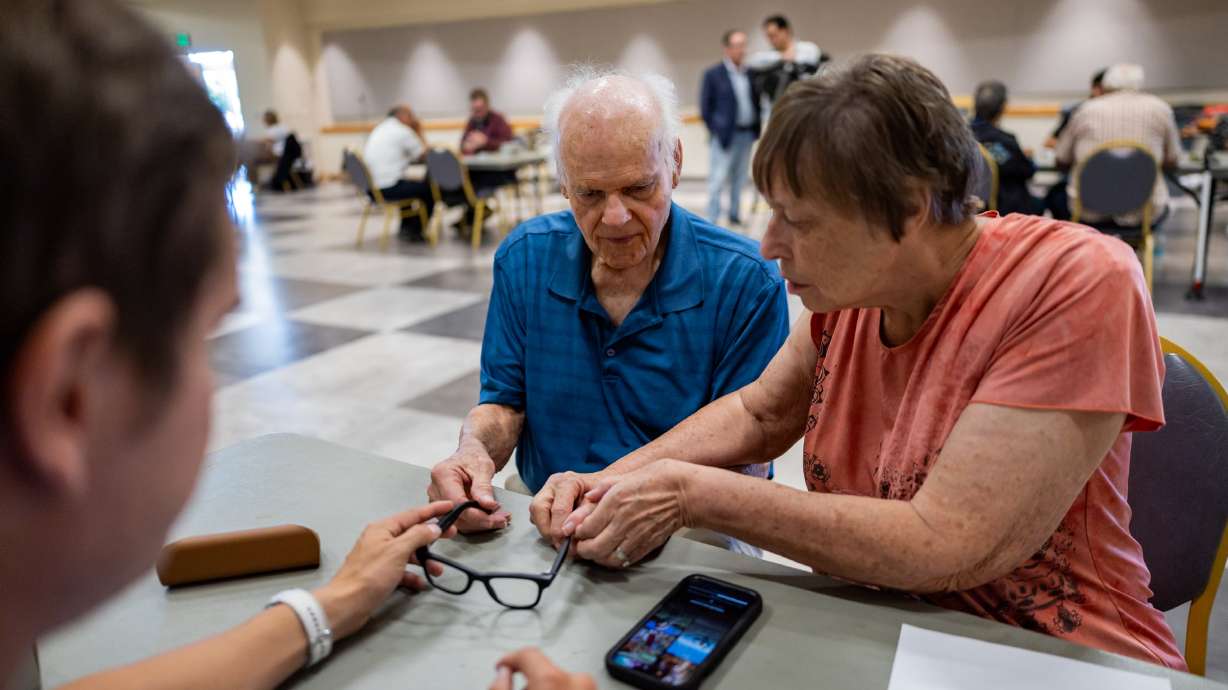 Larry Wade, a Utah veteran, receives help from his wife, Connie Wade, and Chase Harman, lead building engineer for Meta at the Eagle Mountain Data Center, as Harman gives Larry Wade Ray-Ban Meta AI glasses and provides training on how to use the glasses to improve his life at the Utah Division of Services for the Blind and Visually Impaired in Salt Lake City.