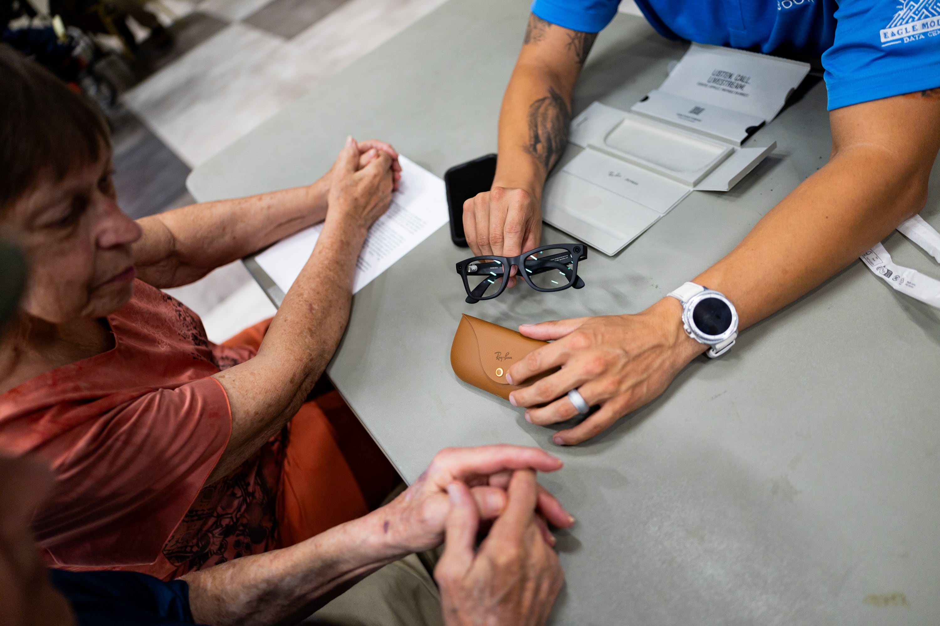 Larry Wade, local veteran from Utah, right, receives help from his wife Connie Wade, left, and Chase Harman, lead building engineer for Meta at the Eagle Mountain Data Center, center, as Harman gives Wade Ray-Ban Meta AI glasses and provides training on how to use the glasses to improve his life at the Utah Division of Services for the Blind and Visually Impaired in Salt Lake City on Tuesday.