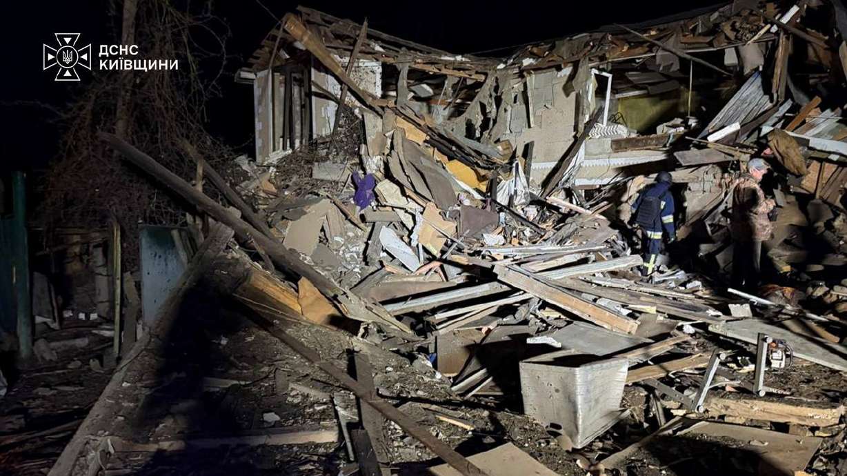 In this photo provided by the Ukrainian Emergency Services on Wednesday, a rescuer walks on a site of a Russian drone strike on residential house in Kyiv region. Officials said Moscow mainly has been targeting the power grid, despite the attacks killing seven people, including a child.