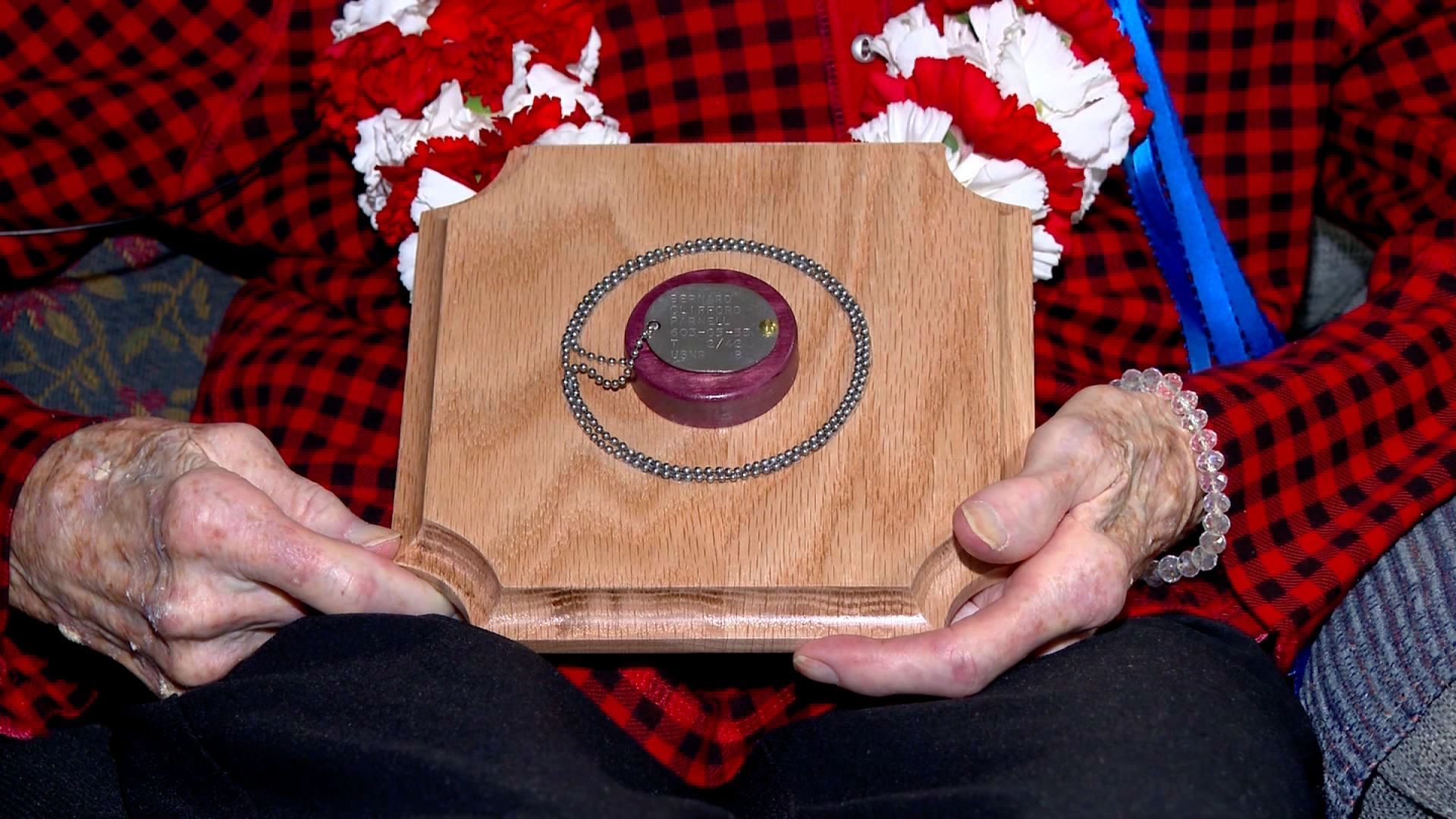 Dorothy Stewart holds her brother's dog tags at her home in Beverly, Mass., Tuesday. After 83 years, Stewart, now 104, finally has her brother's dog tags after his plane crashed during World War II in 1943.