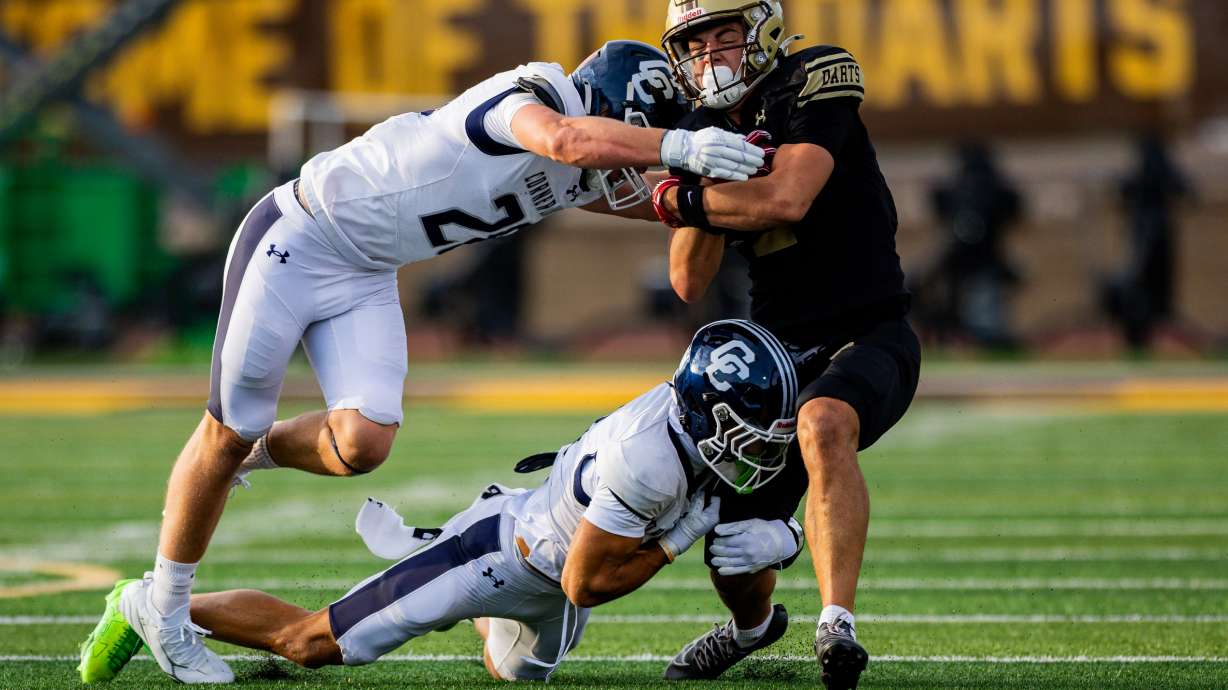 Davis Darts' Bode Sparrow (2) is tackled by the Corner Canyon Chargers during a 6A high school football game at Davis High School in Kaysville on Friday, Aug. 14, 2026.