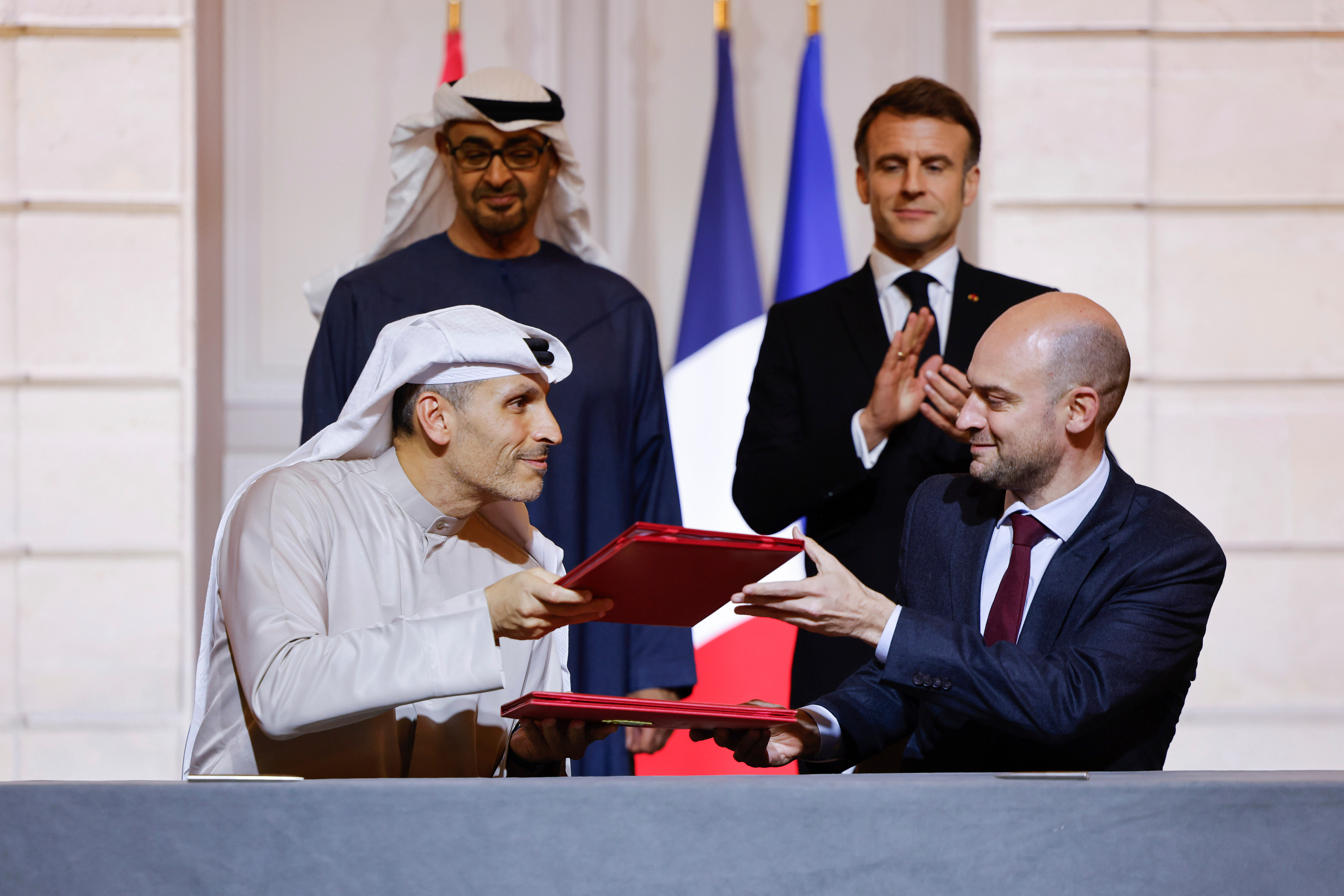 FILE -France's President Emmanuel Macron, rear right, and United Arab Emirates President Sheikh Mohamed bin Zayed Al Nahyan, rear left, look on as France's Minister for Europe and Foreign Affairs Jean-Noel Barrot, right, and CEO of Mubadala Investment Company Khaldoon Al Mubarak, left, sign an agreement on AI, at the Elysee Palace, in Paris, Feb. 6, 2025. , File)