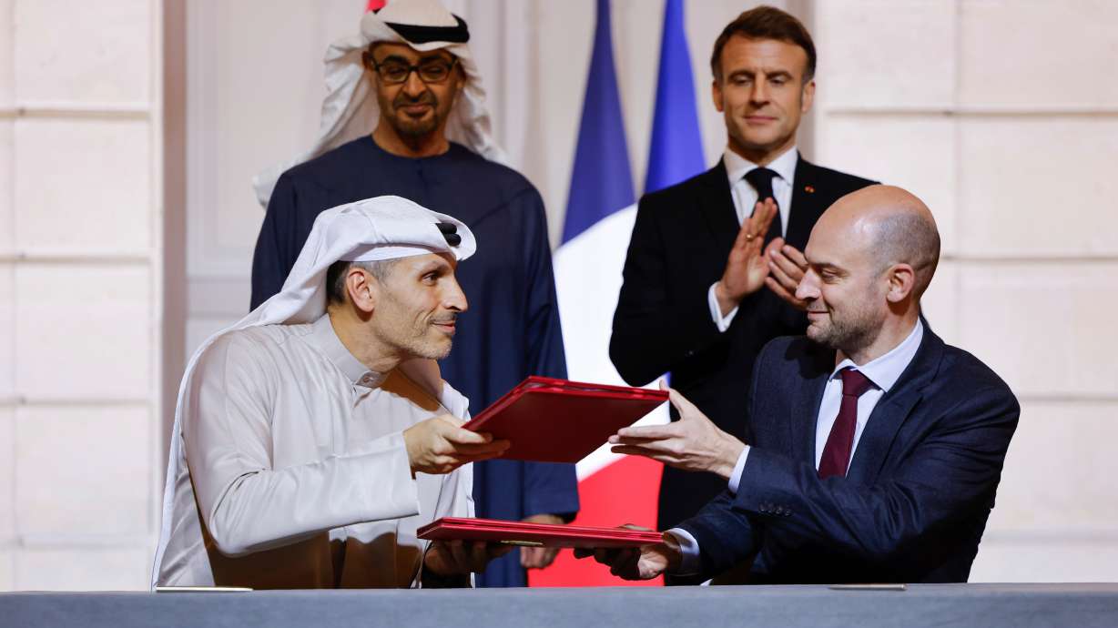 FILE -France's President Emmanuel Macron, rear right, and United Arab Emirates President Sheikh Mohamed bin Zayed Al Nahyan, rear left, look on as France's Minister for Europe and Foreign Affairs Jean-Noel Barrot, right, and CEO of Mubadala Investment Company Khaldoon Al Mubarak, left, sign an agreement on AI, at the Elysee Palace, in Paris, Feb. 6, 2025. , File)