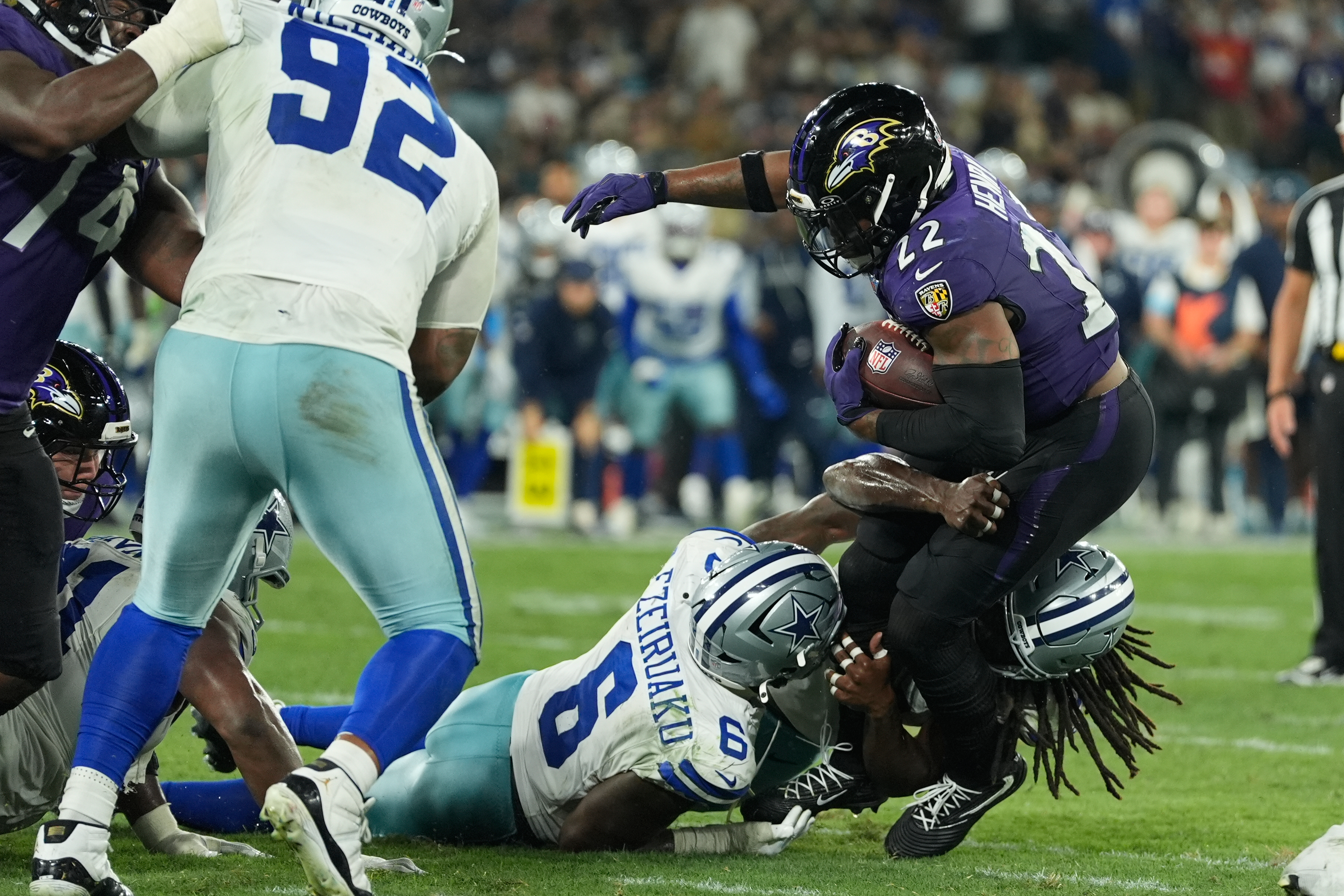 Baltimore Ravens running back Derrick Henry (22) is tackled by Dallas Cowboys linebacker Donovan Ezeiruaku (6) and linebacker Jaishawn Barham (55) during the second half of an NFL football game in Rio de Janeiro, Sunday, Sept. 27, 2026. 