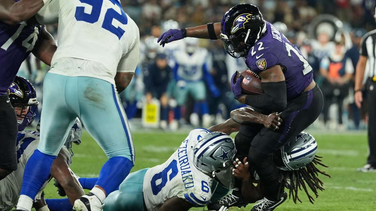 Baltimore Ravens running back Derrick Henry (22) is tackled by Dallas Cowboys linebacker Donovan Ezeiruaku (6) and linebacker Jaishawn Barham (55) during the second half of an NFL football game in Rio de Janeiro, Sunday, Sept. 27, 2026.