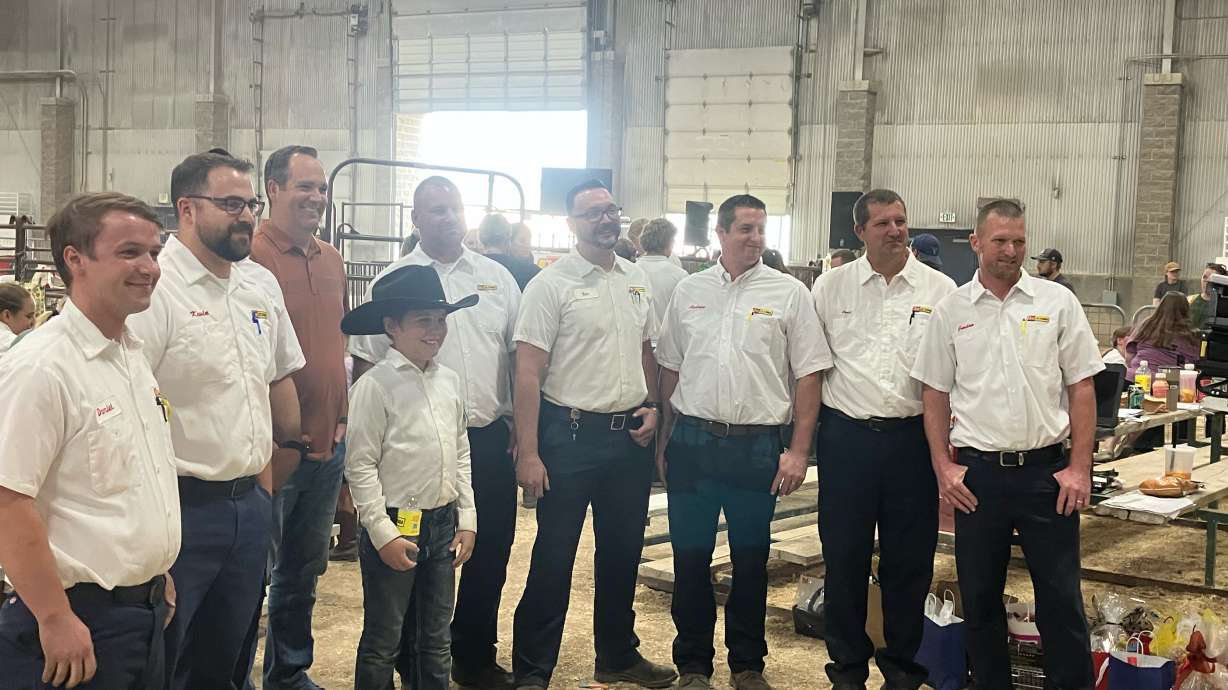 A 4-H member stands with representatives from Les Schwab and the Bastian Family Foundation, who purchased his lamb at the Salt Lake County Junior Livestock Auction and helped raise approximately $15,000 in support of the young exhibitor and his family.
