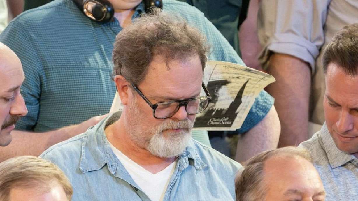 Rainn Wilson looks at choir music during a rehearsal for the Tabernacle Choir last week. He interacted with the choir while working on a documentary about what God means in the modern world.
