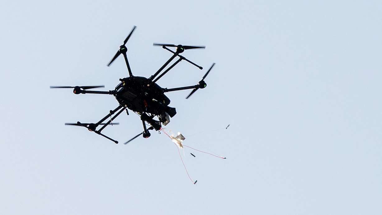 A drone-hunter drone fires a net toward a small drone in a demonstration flight at counter-drone leader Fortem Technologies' advanced manufacturing headquarters in Lindon on June 17, 2025.