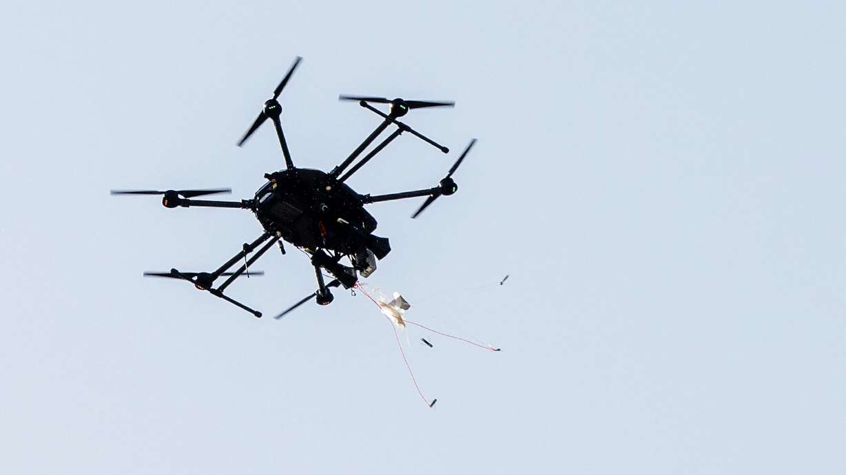 A drone-hunter drone fires a net toward a small drone in a demonstration flight as counter-drone leader Fortem Technologies celebrates the opening of its advanced manufacturing headquarters in Lindon on June 17, 2025.