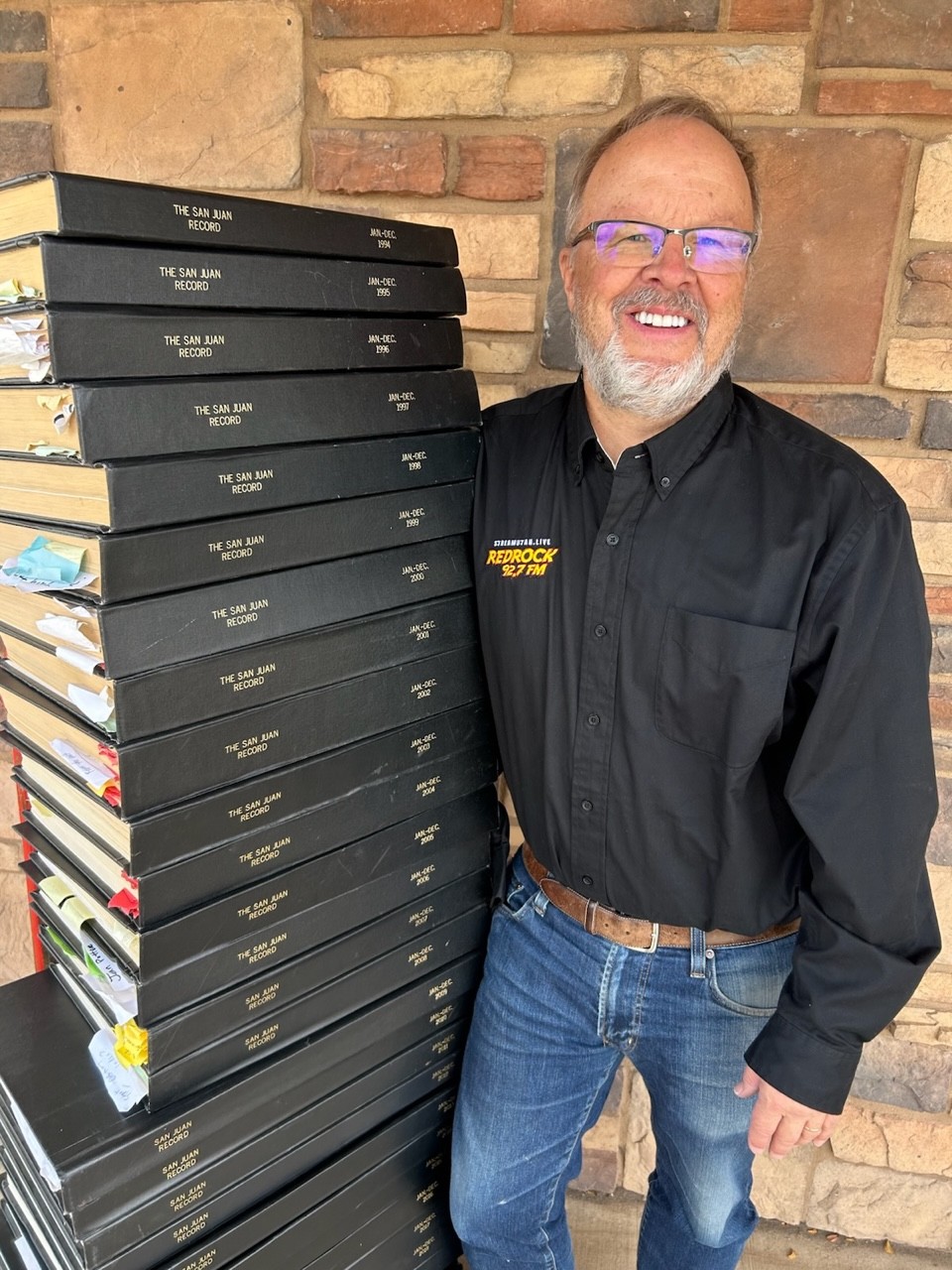 San Juan Record Editor and Publisher Bill Boyle next to a stack of newspaper archives on Wednesday.