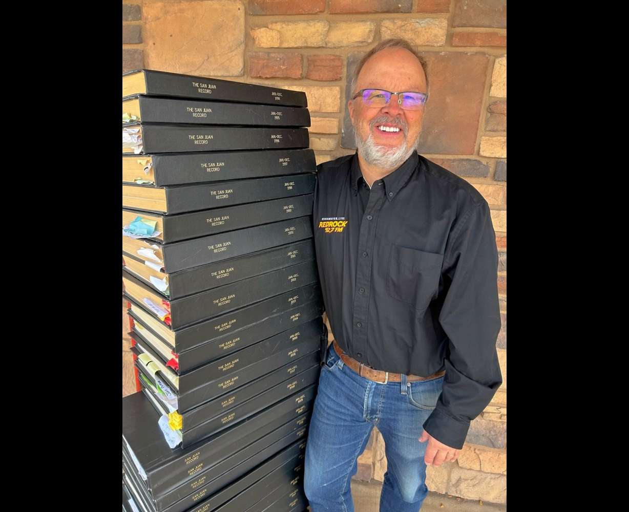 San Juan Record Editor and Publisher Bill Boyle next to a stack of newspaper archives on Wednesday.