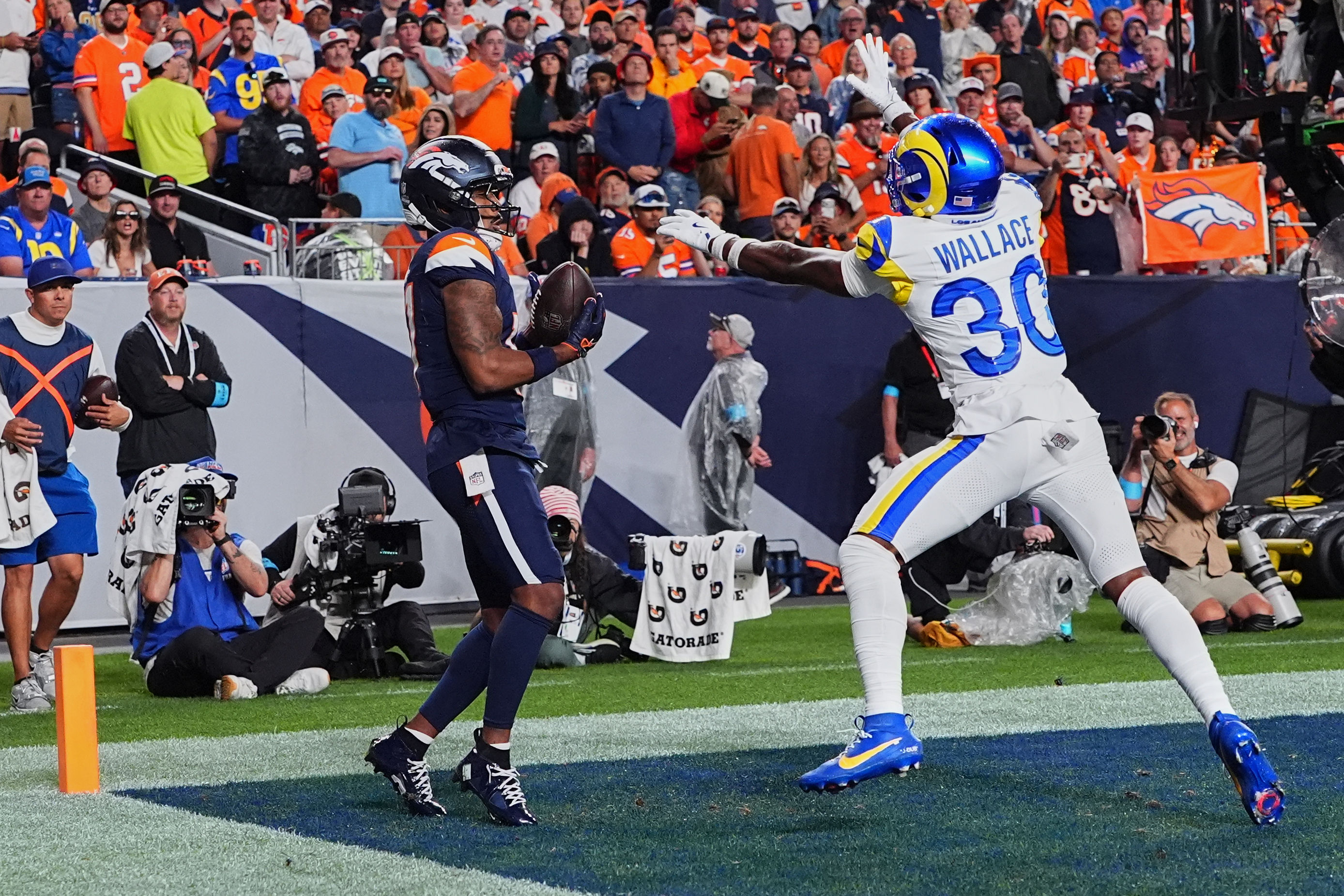 Denver Broncos wide receiver Jaylen Waddle, left, catches a touchdown pass against Los Angeles Rams cornerback Josh Wallace during the second half of an NFL football game Sunday, Sept. 27, 2026, in Denver.