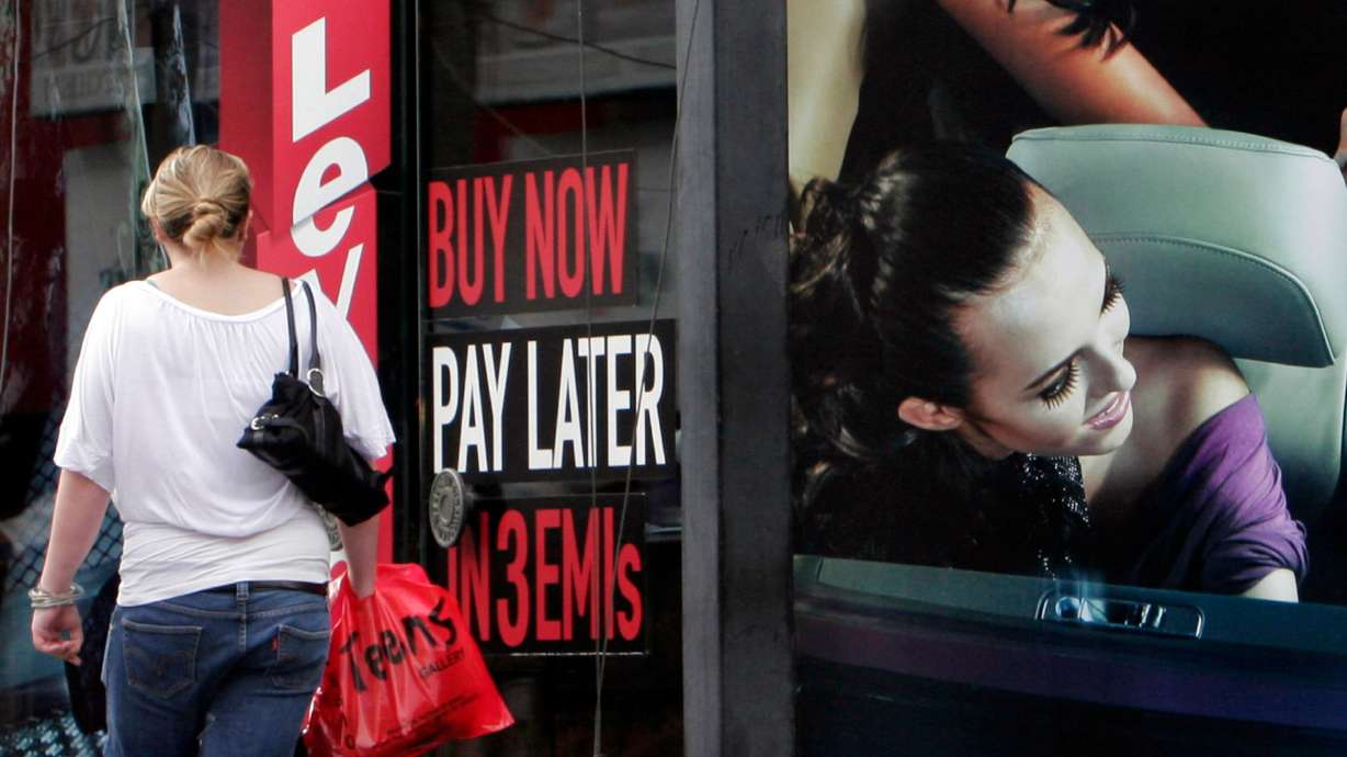 A woman walks by a sign "Buy now pay later" at a store in Bangalore, India, on Sept. 10, 2009.