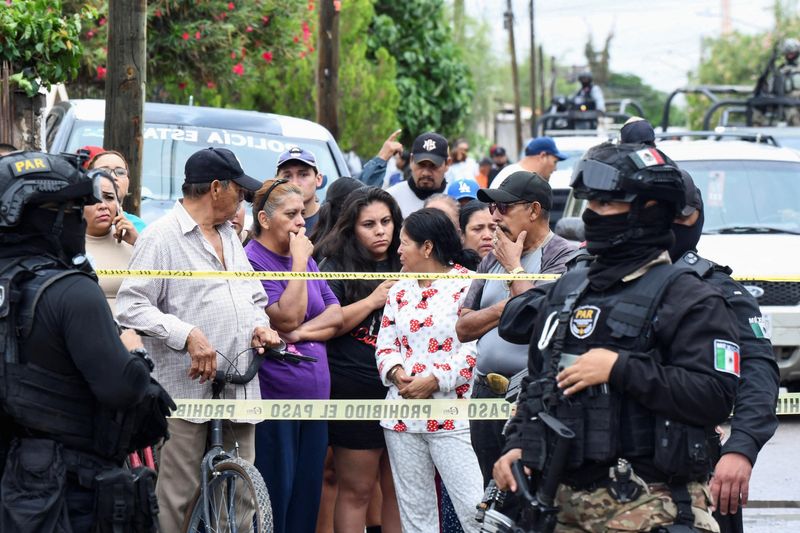 Onlookers stand behind a police cordon as security officers stand guard at Secondary School No. 13 after an attack that killed a vice principal and injured others, according to local authorities, in Torreon, Coahuila state, Mexico, October 1, 2026.