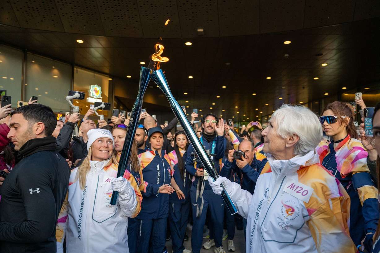 Gail Miller passes the flame during the 2026 Milan Cortina Winter Games torch run in Milan, Italy, on Feb. 5.