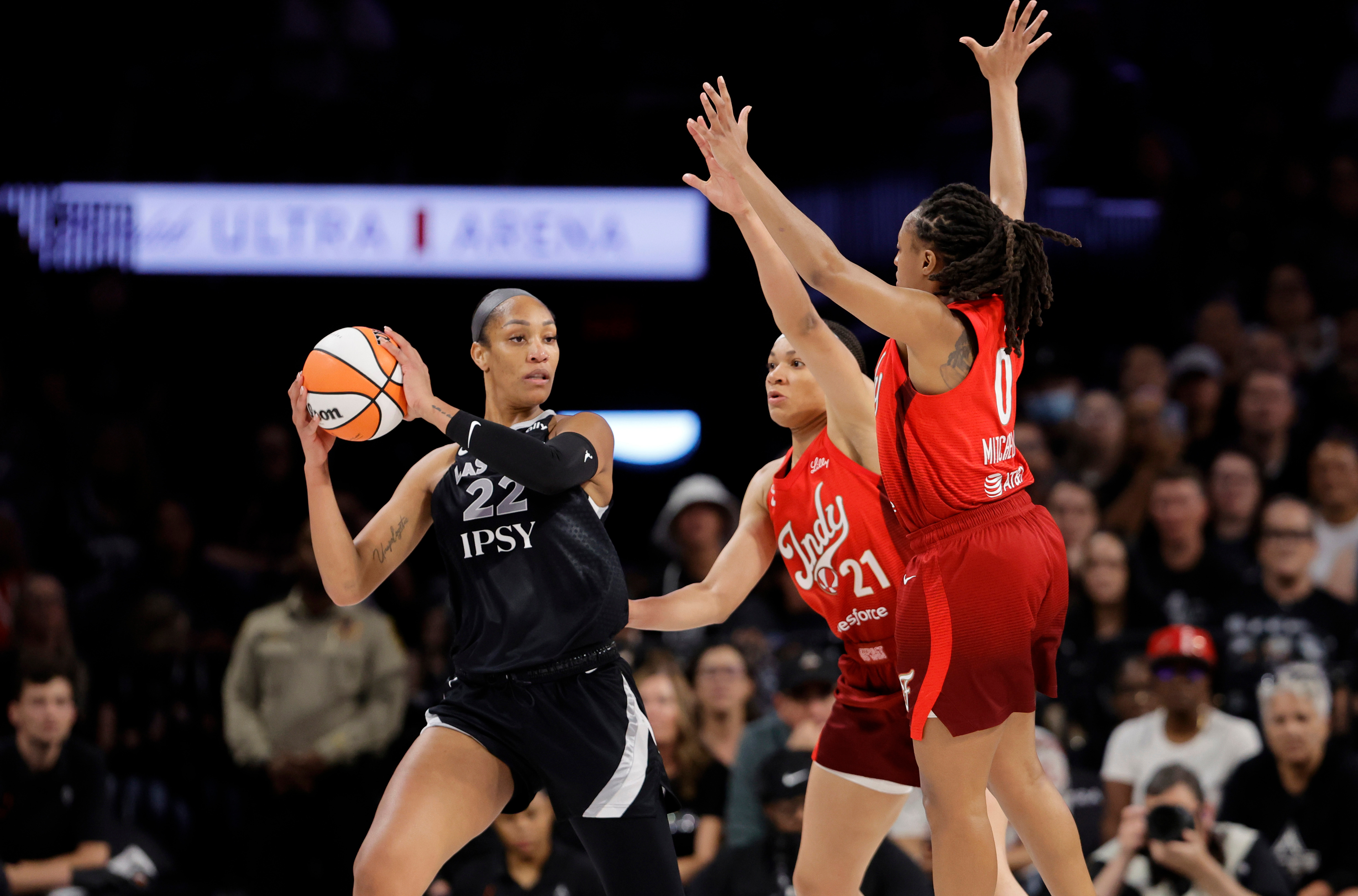Las Vegas Aces center A'ja Wilson (22) is pressured by Indiana Fever forward Makayla Timpson (21) and guard Kelsey Mitchell (0) during the first half in Game 3 of an WNBA basketball first-round playoff series Thursday, Oct.1, 2026, in Las Vegas. 
