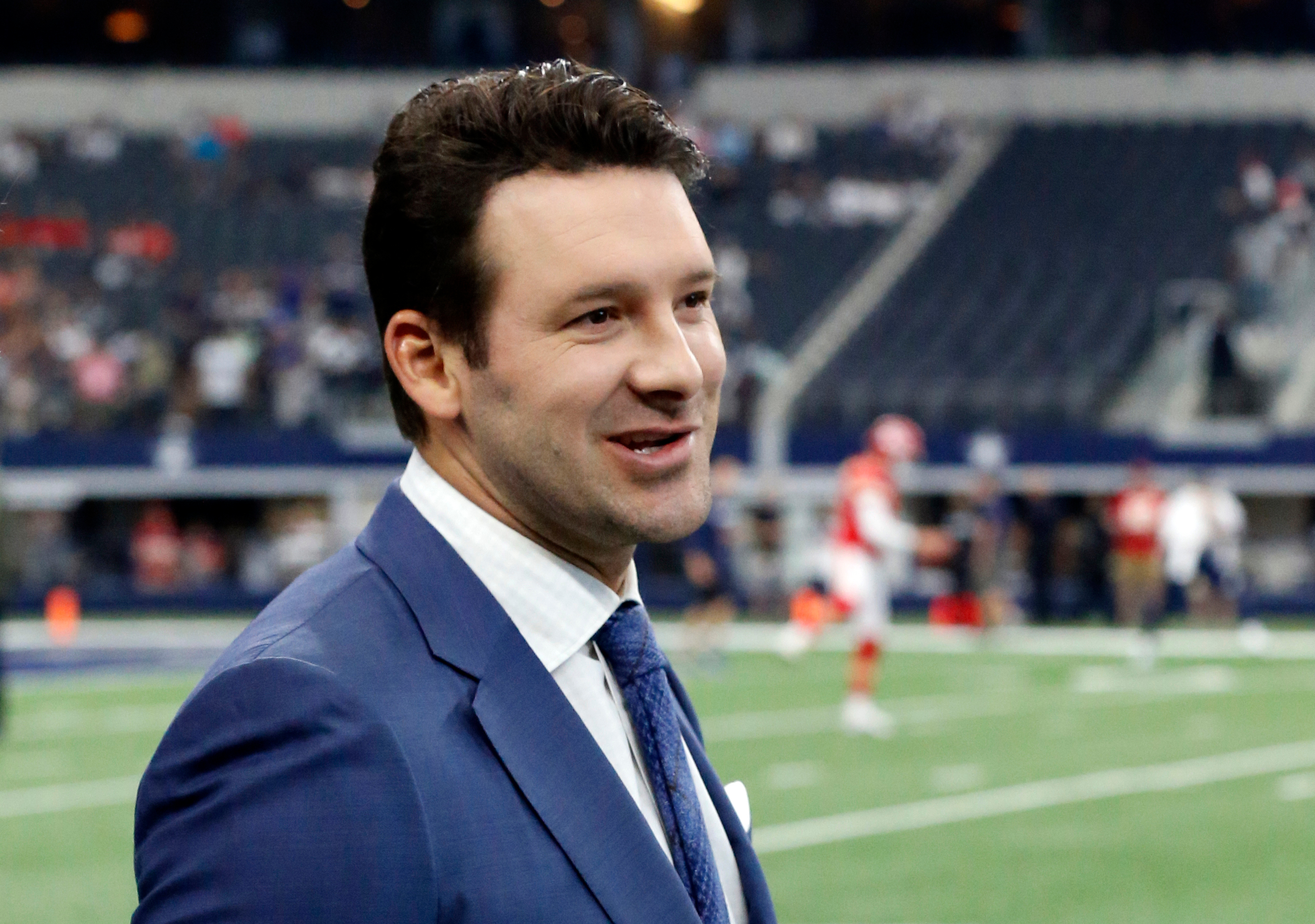 FILE - In this Nov. 5, 2017, file photo, CBS football analyst Tony Romo walks across the field during warm ups before an NFL football game between the Kansas City Chiefs and Dallas Cowboys, in Arlington, Texas. 