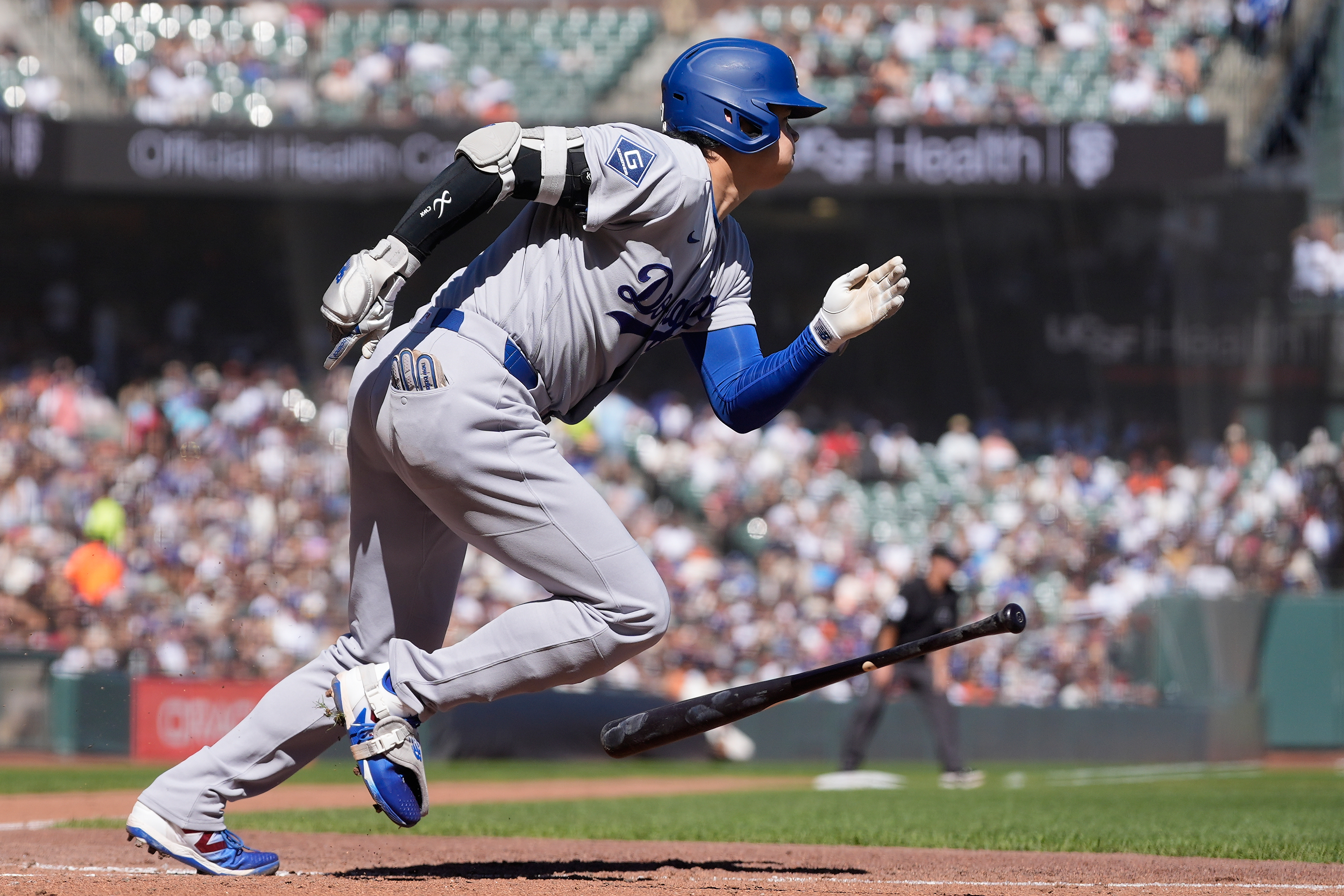 Los Angeles Dodgers designated hitter Shohei Ohtani runs to first base after hitting a single during the fifth inning of a baseball game against the San Francisco Giants, Saturday, Sept. 26, 2026, in San Francisco. 