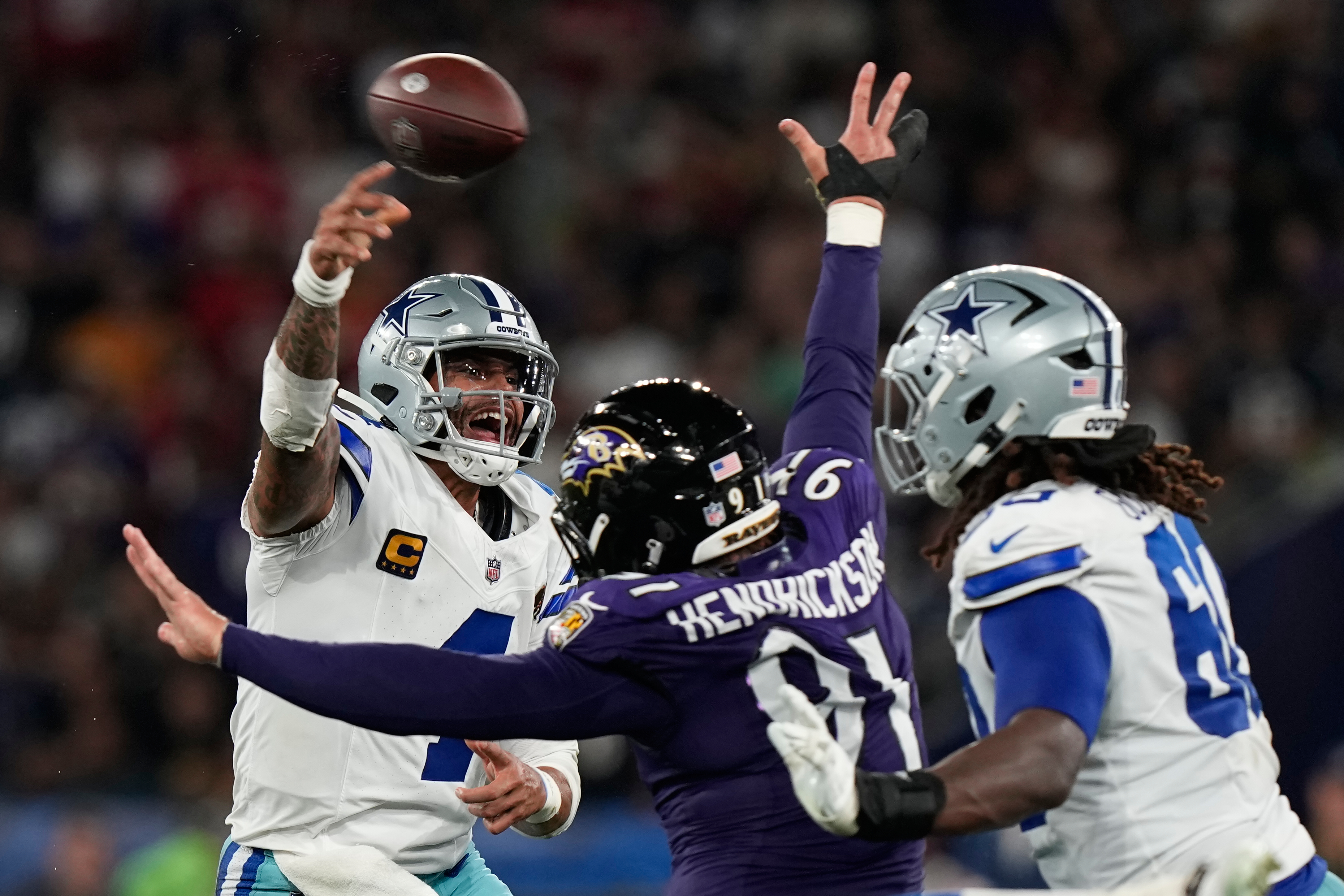 Dallas Cowboys quarterback Dak Prescott (4) throws while threatened by Baltimore Ravens linebacker Trey Hendrickson (91) during the first half of an NFL football game in Rio de Janeiro, Sunday, Sept. 27, 2026. 