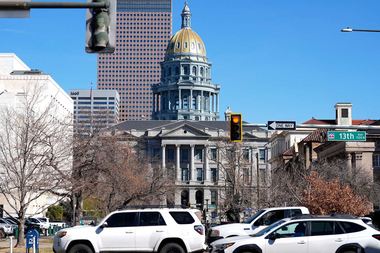 Traffic hurries along 13th Avenue in the foreground as the gold dome of the State Capitol gleams in the early-morning sun March 25, 2025, in Denver.