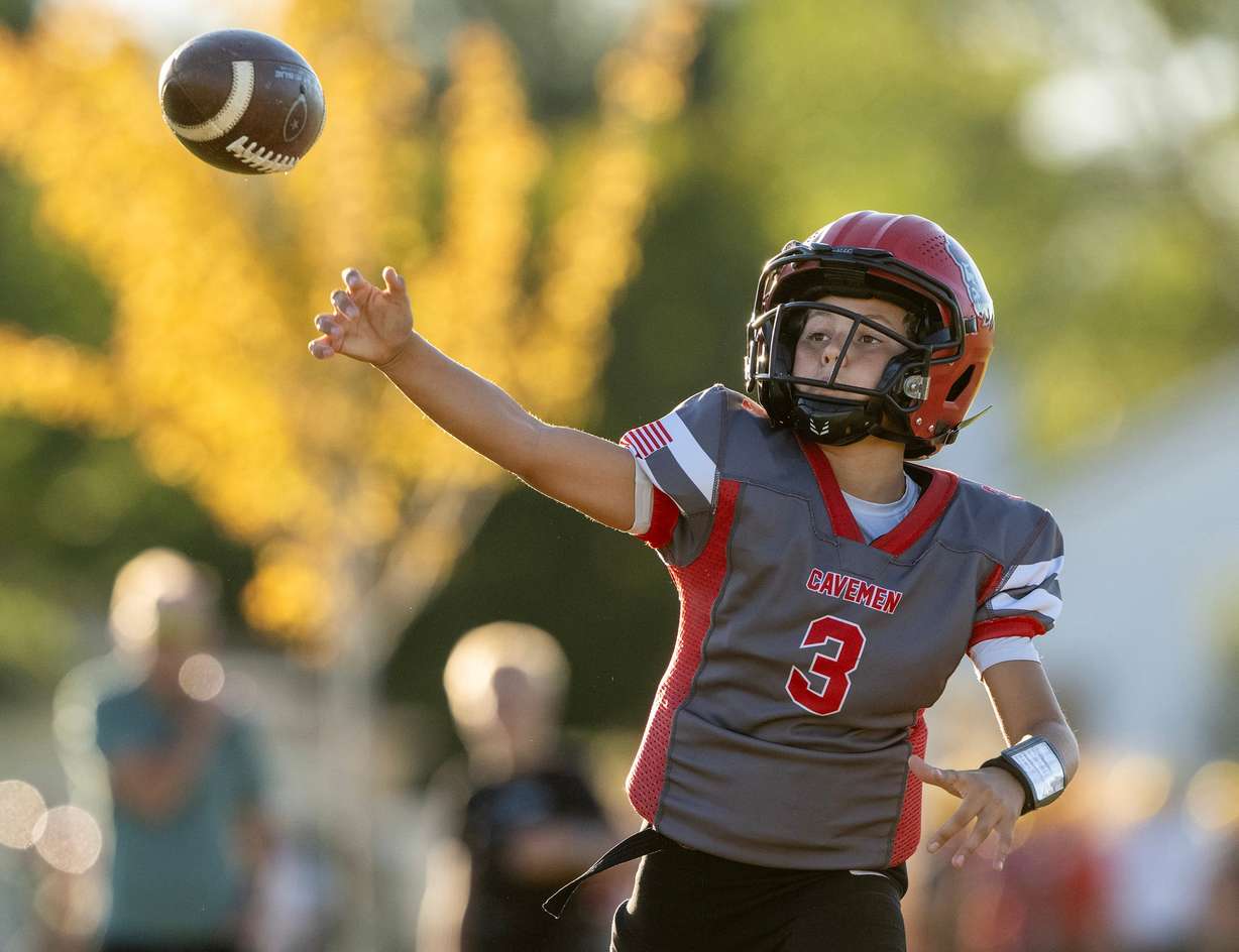 Camden Roche delivers a pass during a play as members of a youth football team in American Fork go through their practice at American Fork Jr. High on Sept. 23. Roughly 20,000 kids play football statewide.