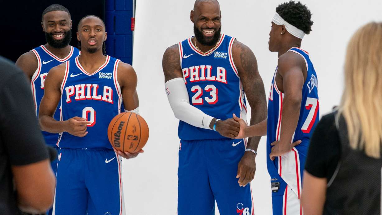 Philadelphia 76ers' LeBron James, center right, greats VJ Edgecombe, right, as they get ready for a group photos with Tyrese Maxey, center left, and Jaylen Brown, left, during the NBA basketball team's media day, Monday, Sept. 28, 2026, in Camden, N.J..
