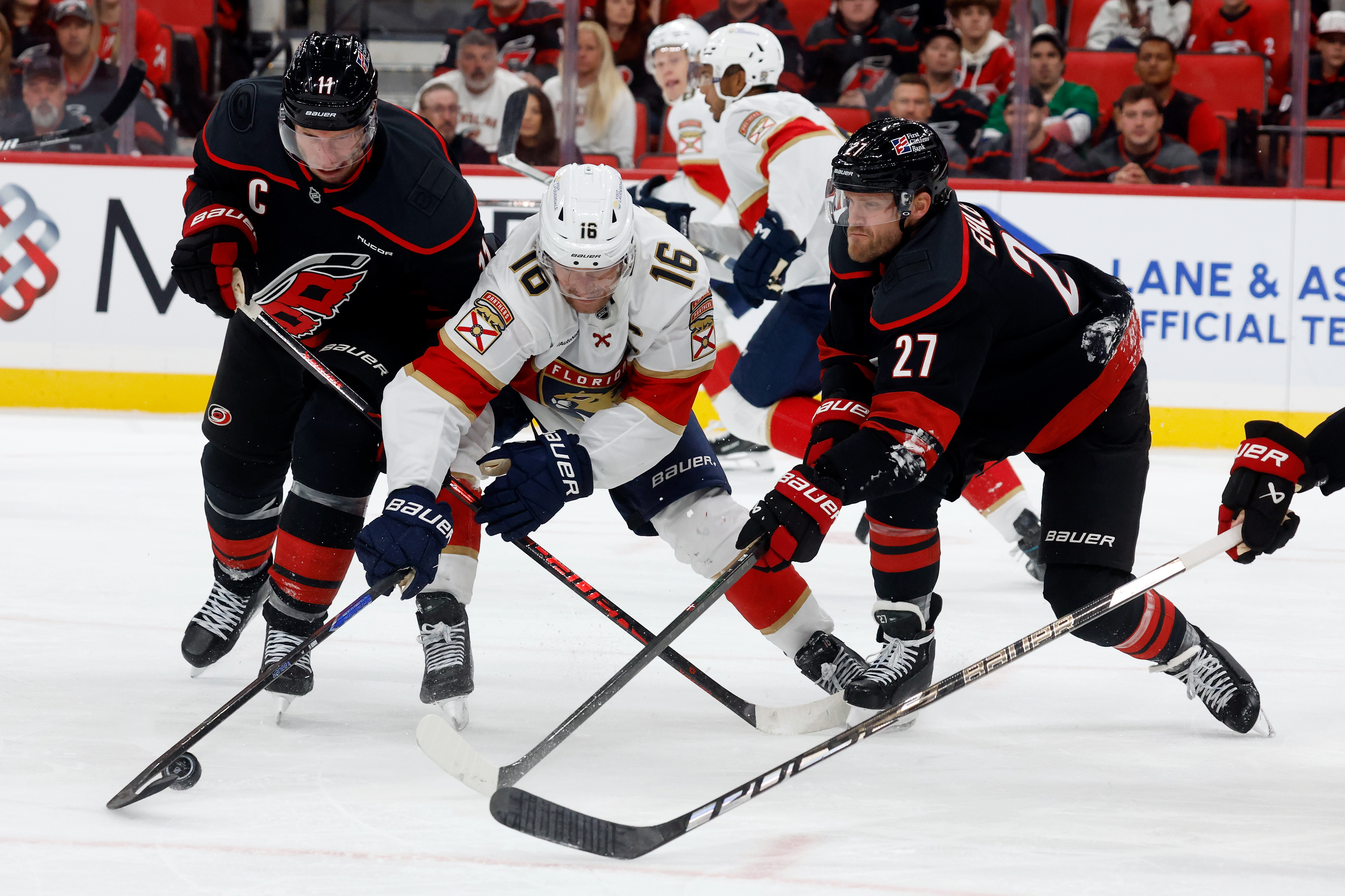 Florida Panthers' Aleksander Barkov (16) battles for the puck between Carolina Hurricanes' Jordan Staal, left, and Nikolaj Ehlers (27) during the third period of an NHL hockey game in Raleigh, N.C., Tuesday, Sept. 29, 2026. 