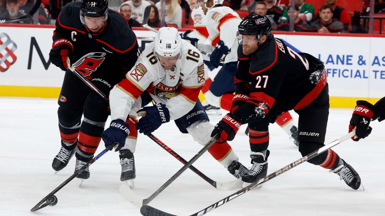 Florida Panthers' Aleksander Barkov (16) battles for the puck between Carolina Hurricanes' Jordan Staal, left, and Nikolaj Ehlers (27) during the third period of an NHL hockey game in Raleigh, N.C., Tuesday, Sept. 29, 2026.