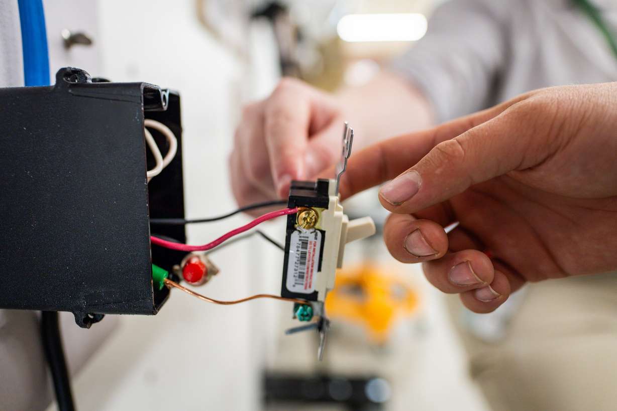 First-year students in the electrical program use the practice boards at an Ensign College open house celebrating the opening of its new electrical training program at the Vocational Technical Center in Salt Lake City on Friday.