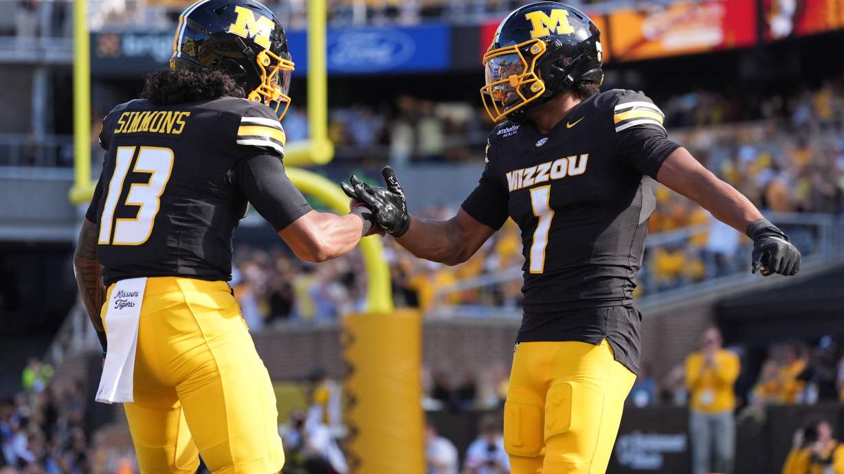 Missouri wide receiver Donovan Olugbode (1) is congratulated by quarterback Austin Simmons (13) after scoring during the first half of an NCAA college football game against Florida Saturday, Oct. 3, 2026, in Columbia, Mo.