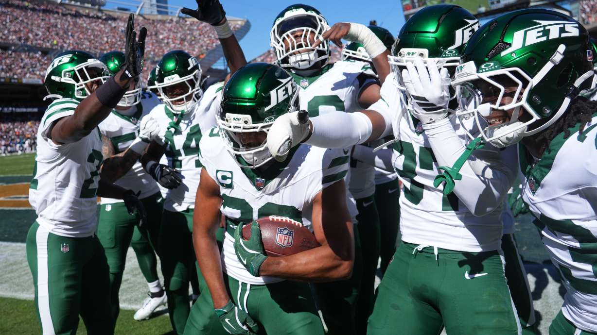 New York Jets safety Minkah Fitzpatrick holds the ball as he celebrates with teammates after intercepting a pass during the first half of an NFL football game against the Chicago Bears Sunday, Oct. 4, 2026, in Chicago.