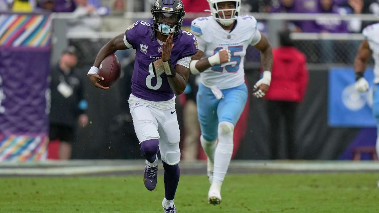 Baltimore Ravens quarterback Lamar Jackson (8) runs the ball past Tennessee Titans defensive end Keldric Faulk (15) during the first half of an NFL football game in Baltimore, Sunday, Oct. 4, 2026.