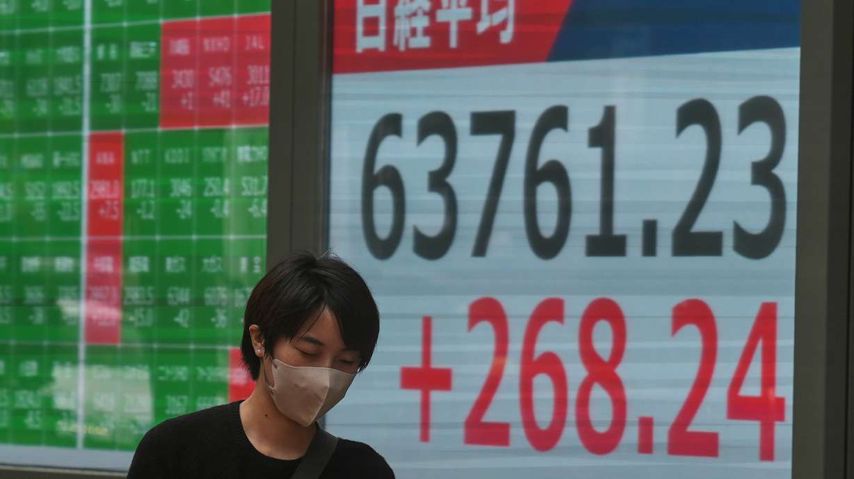 A person walks in front of an electronic stock board showing Japan's Nikkei index at a securities firm Sept. 15, in Tokyo.