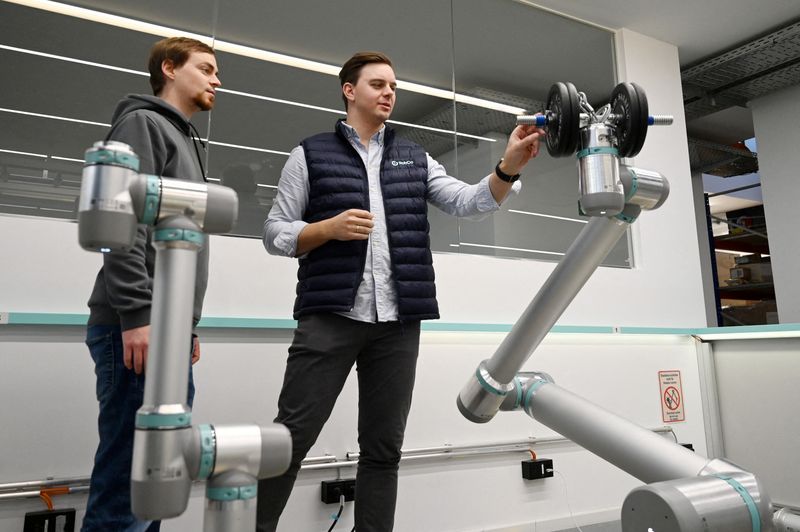 FILE PHOTO: Co-Founder and CEO of RobCo Roman Hoelzl reviews robot functions with a colleague at the company’s facility in Munich, Germany, on February 5, 2026.