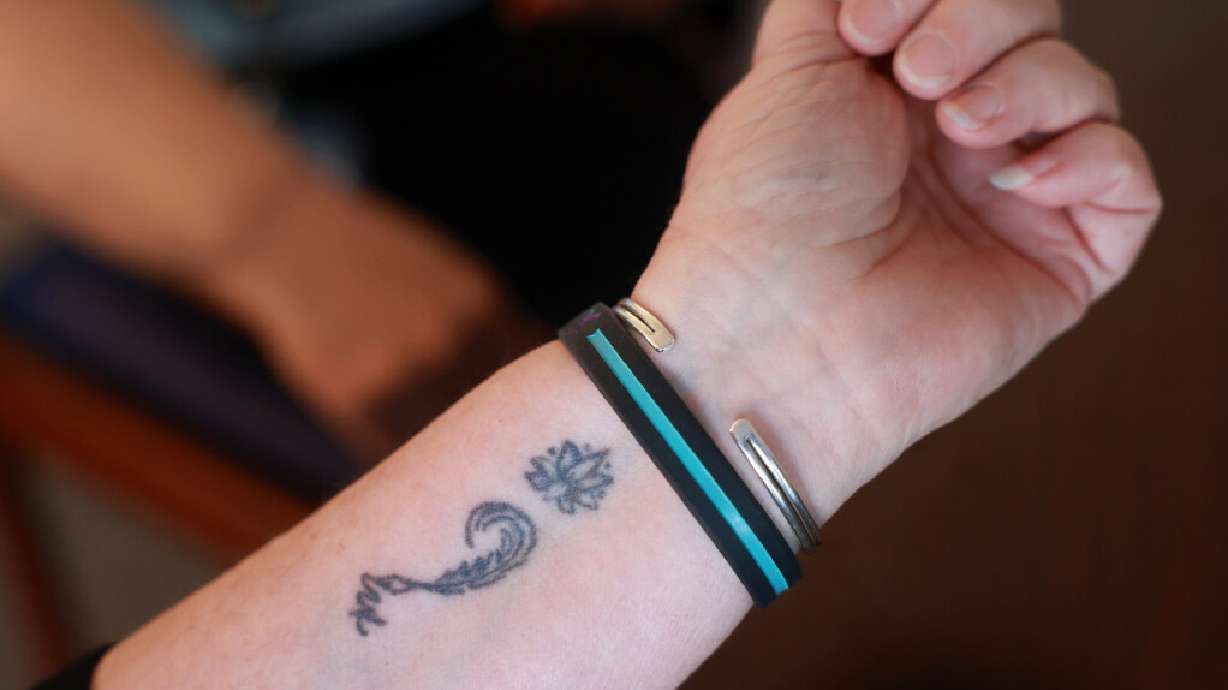 Salt Lake County tax lien coordinator Ray Lancaster, who lost her son to suicide, shows her semicolon tattoo, a symbol of suicide prevention and mental health awareness, during an interview at the Salt Lake County Government Center in Salt Lake City on Sept. 3. As Mental Illness Awareness Week shines a spotlight on mental health challenges, experts say understanding the signs of emotional distress and reducing stigma can help save lives.