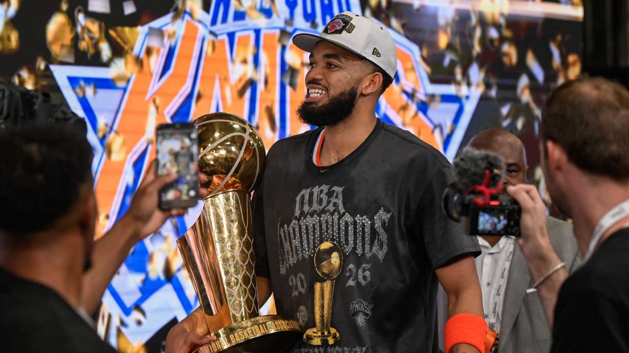 FILE - New York Knicks center Karl-Anthony Towns carries the Larry O'Brien Championship Trophy after the team defeated the San Antonio Spurs in Game 5 of the NBA Finals basketball series June 13, 2026, in San Antonio.