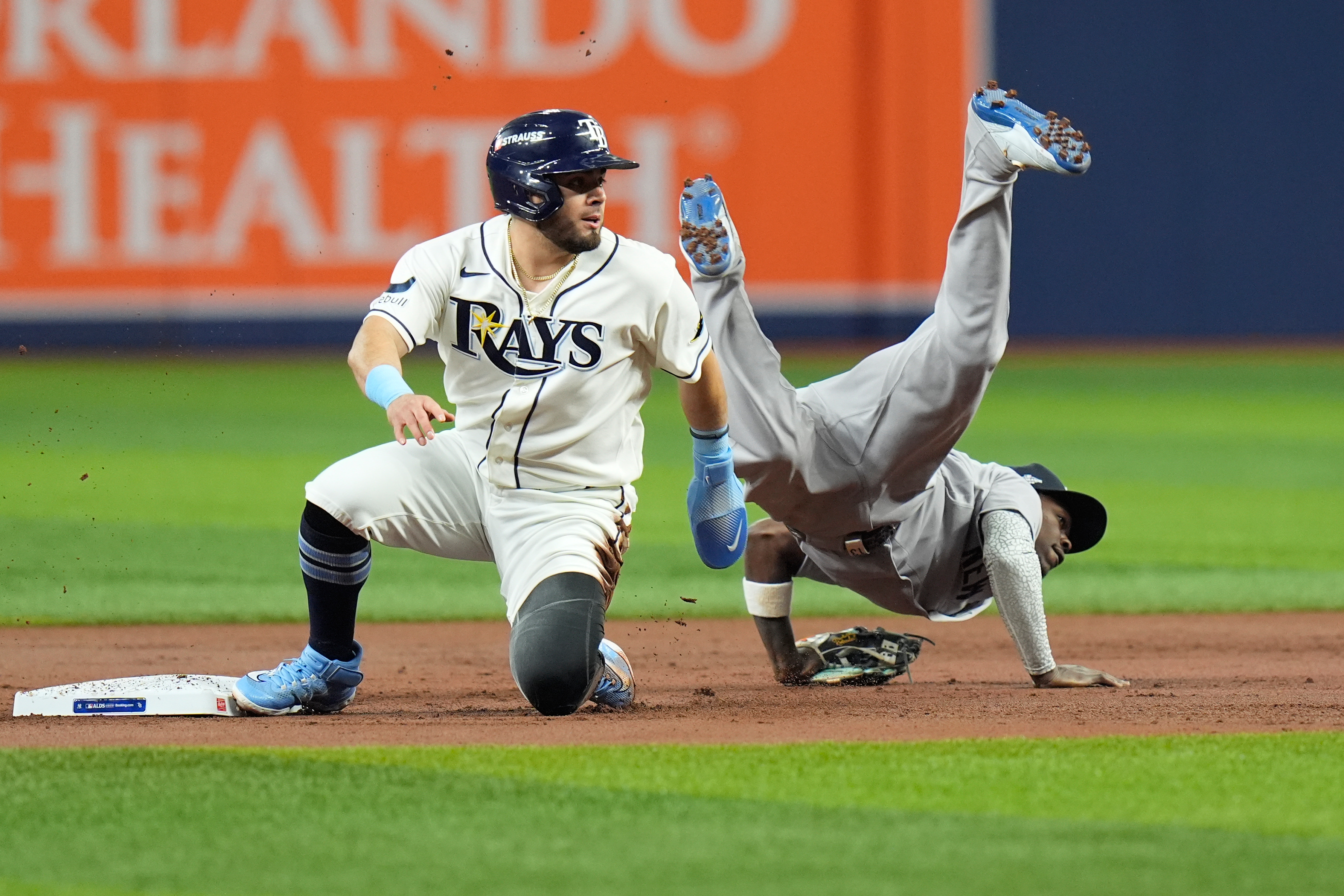 New York Yankees second baseman Jazz Chisholm Jr., right, flips over Tampa Bay Rays' Jonathan Aranda, left, while committing a throwing error allowing Rays' Yandy Díaz to score during the first inning in Game 2 of an American League Division Series baseball game Monday, Oct. 5, 2026, in St. Petersburg, Fla. 