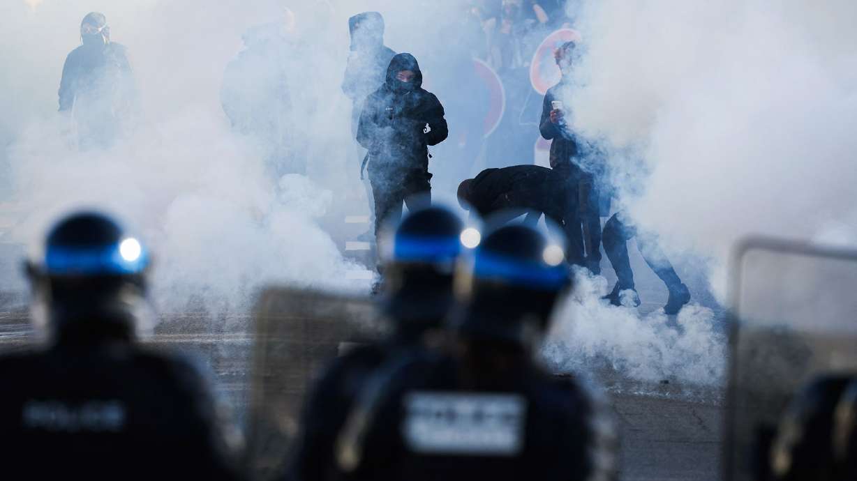 Police officers stand in front of protesters amid tear gas as demonstrators carry out blockading action near the Kerichen high school in Brest, western France, on Oct. 2.